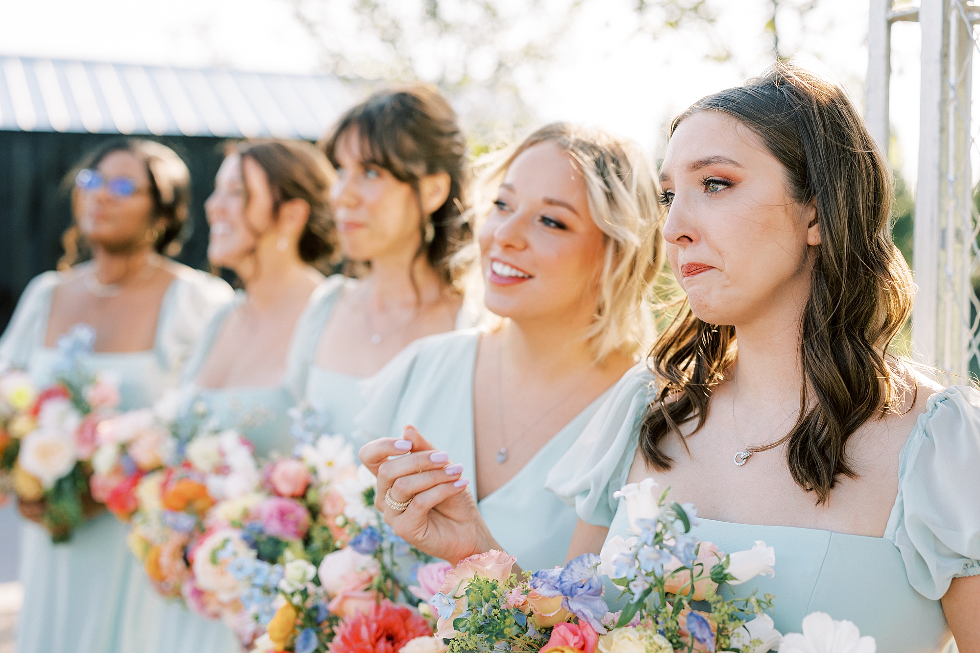 bridesmaids in light blue watch bride enter ceremony and cry