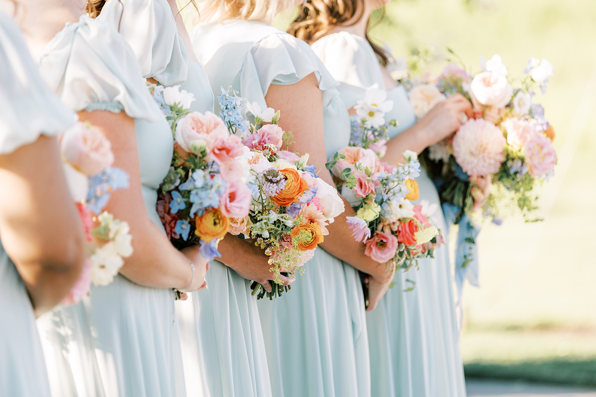 bridesmaids hold colorful bouquets during wedding ceremony in Doylestown PA