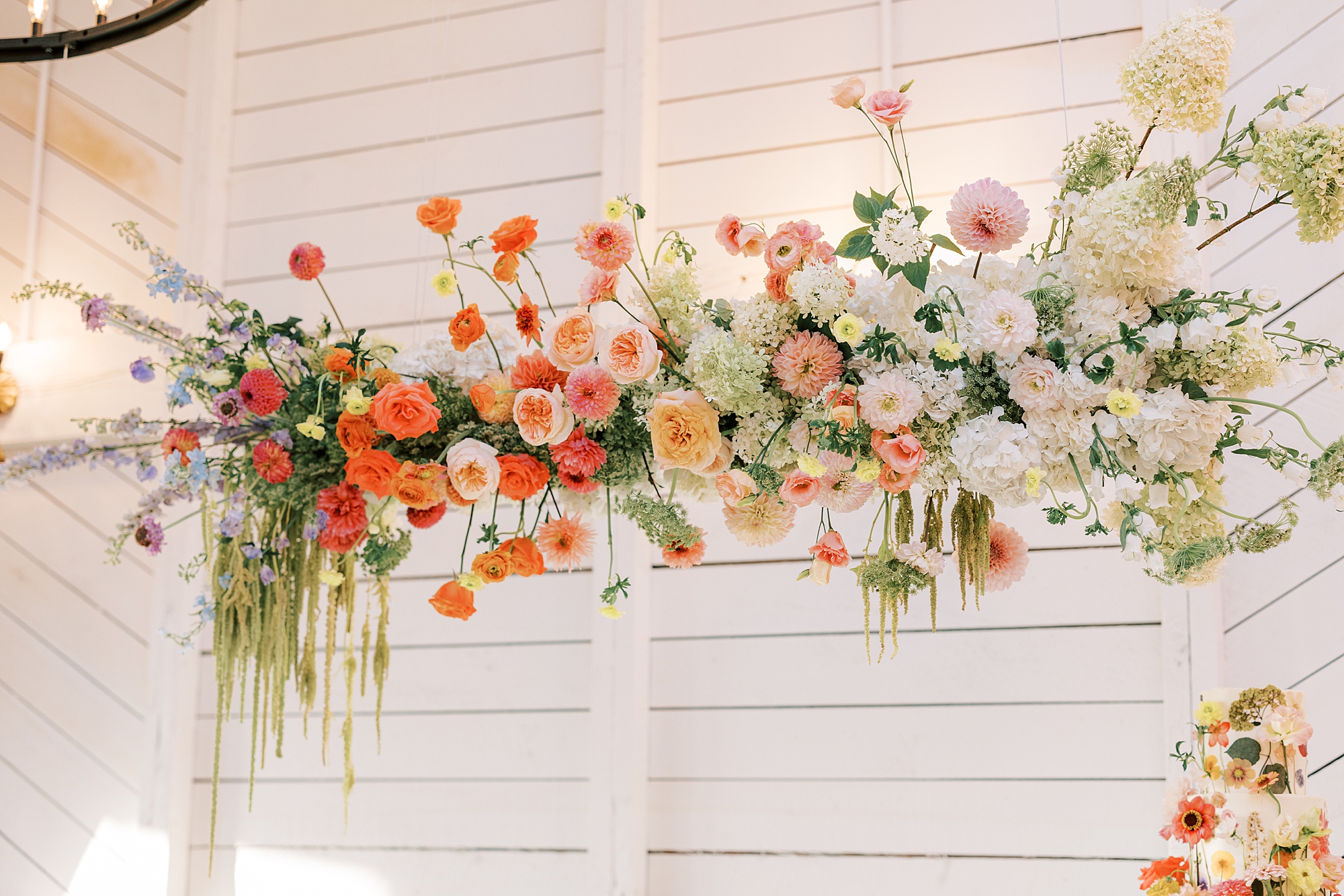 white, pink and orange roses line arbor above sweetheart table