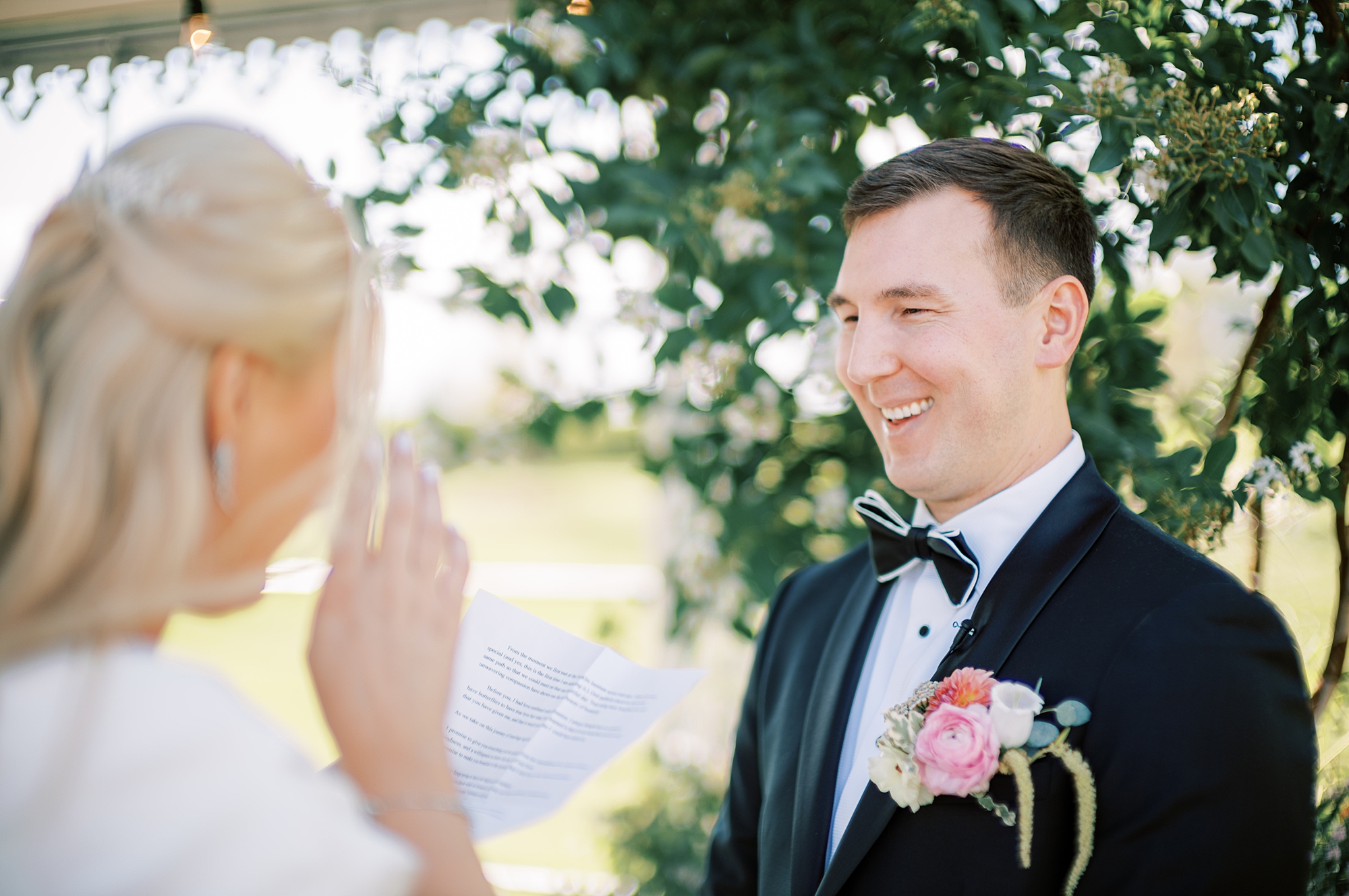 groom grins at bride during first look and vow exchange 