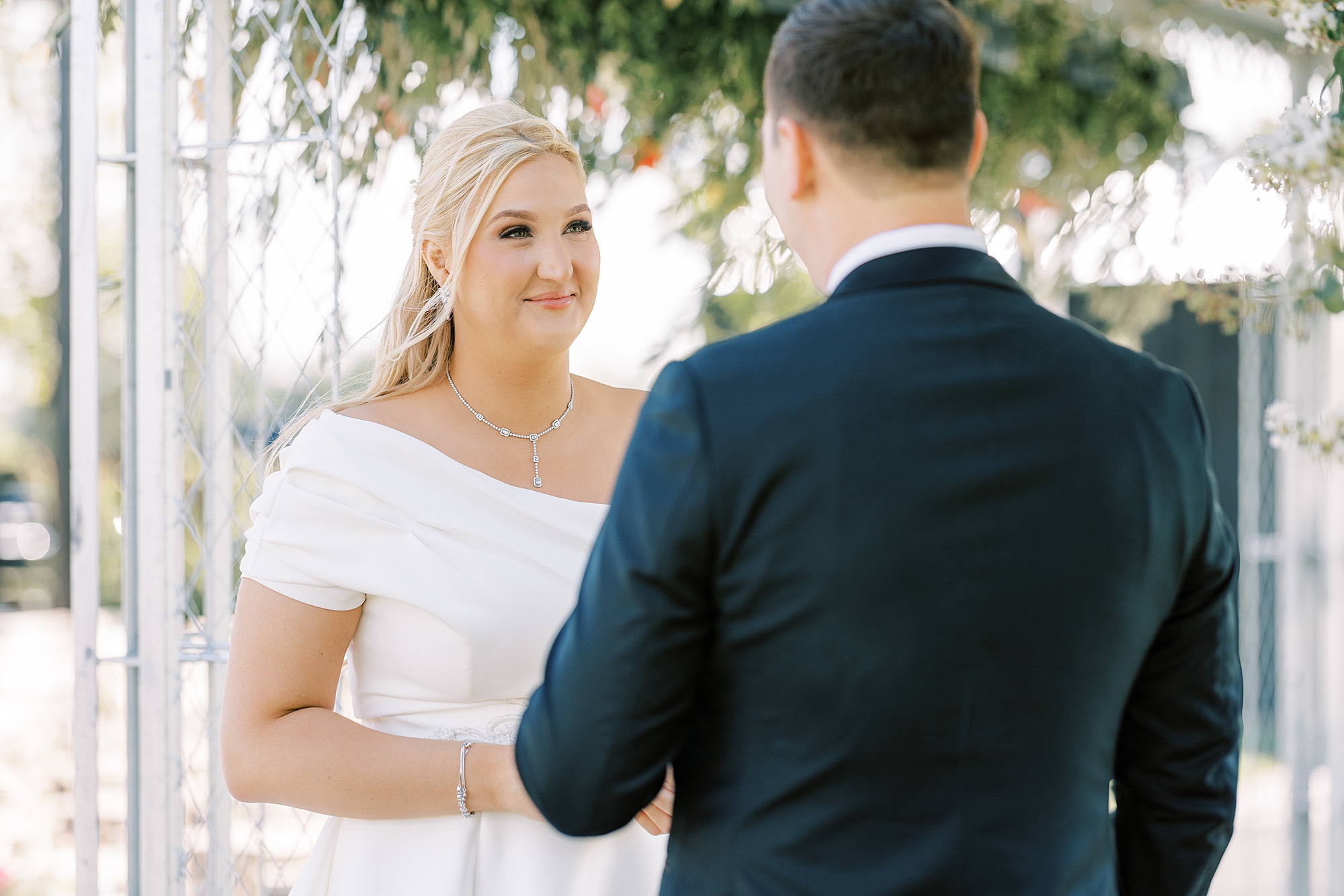 bride grins listening to groom read vows during first look