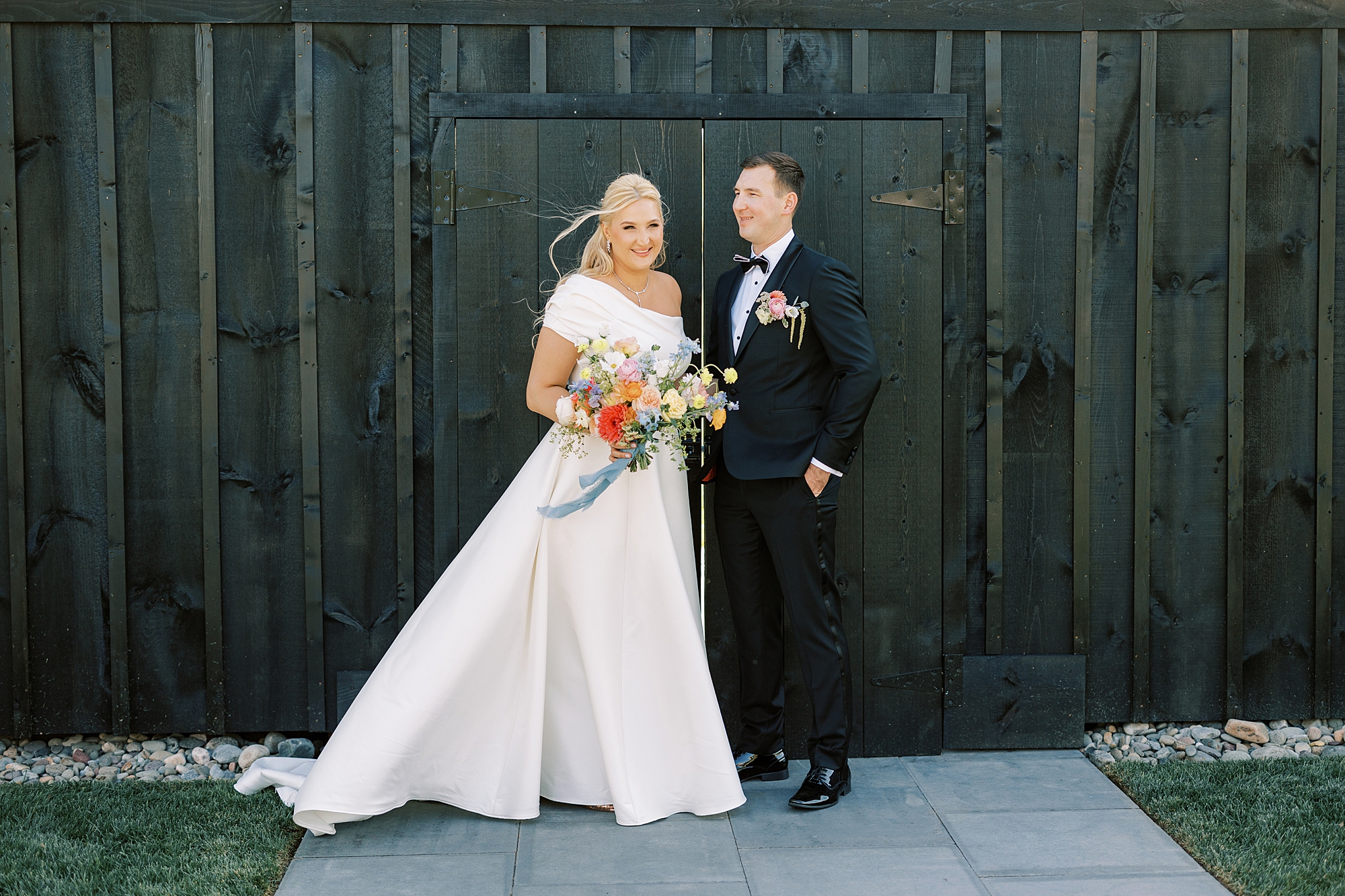 bride and groom stand by green wooden shed at Terrain DelVal