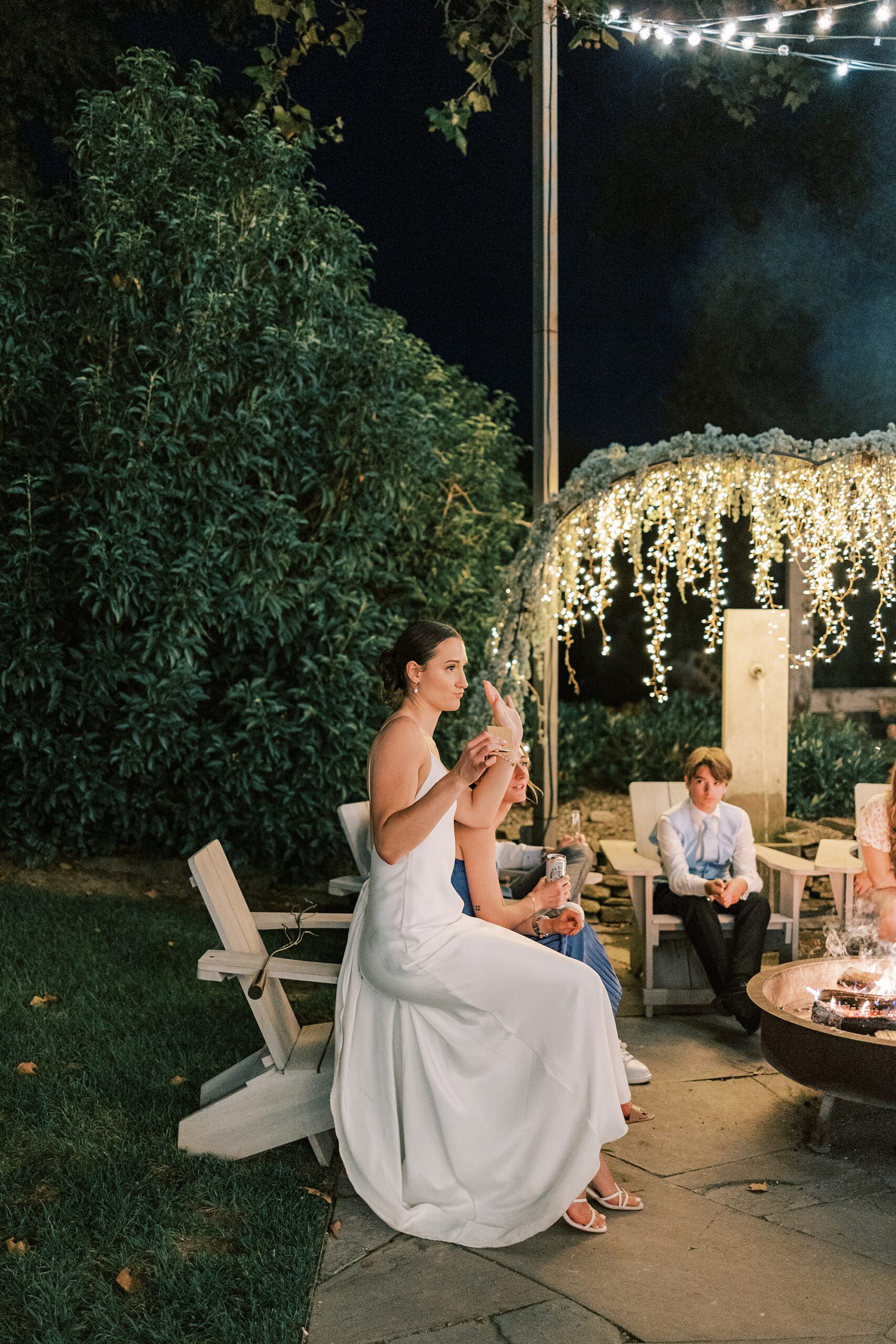 bride sits on lawn chair by fire pit at the Terrain at Styer's in Glen Mills PA