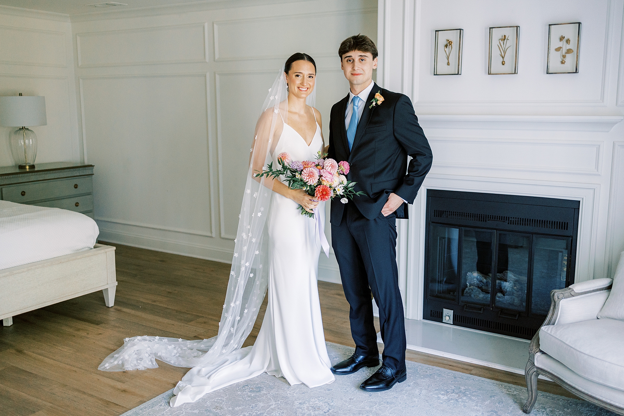 bride and brother pose by fireplace inside Fairville Inn in Chadds Ford