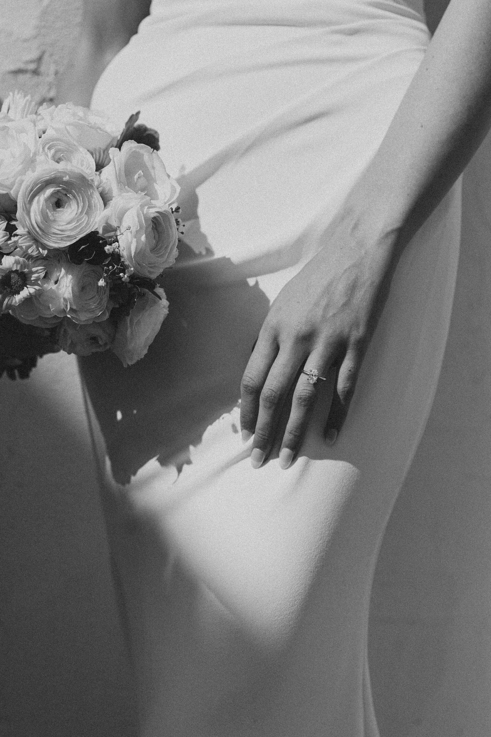 bride rests hand on thigh holding bouquet in other hand