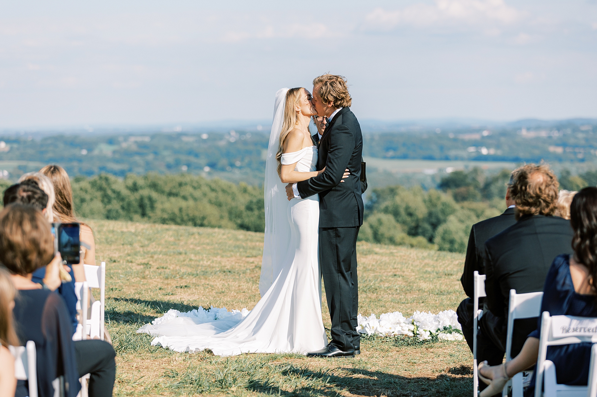 bride and groom kiss during summer wedding ceremony at Lauxmont Farms