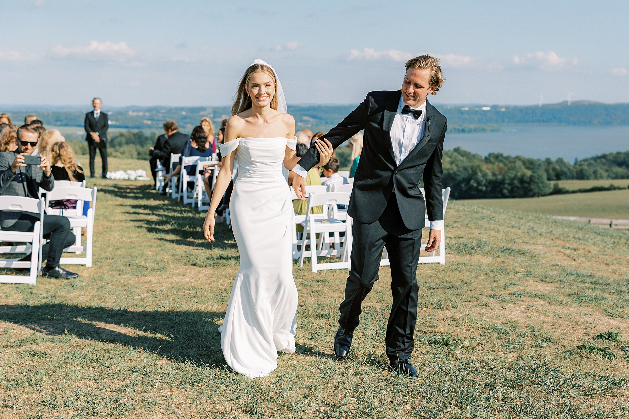 newlyweds bump hips leaving aisle of wedding ceremony 