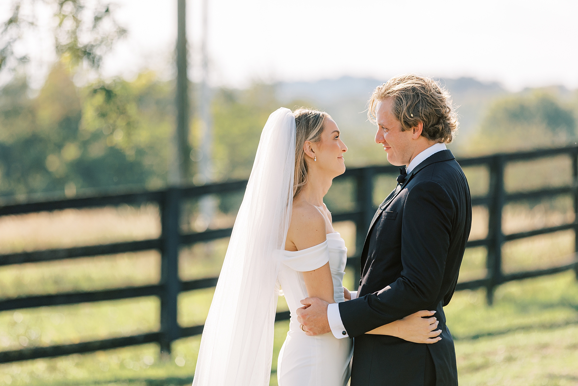 bride and groom hug near fence at Lauxmont Farms