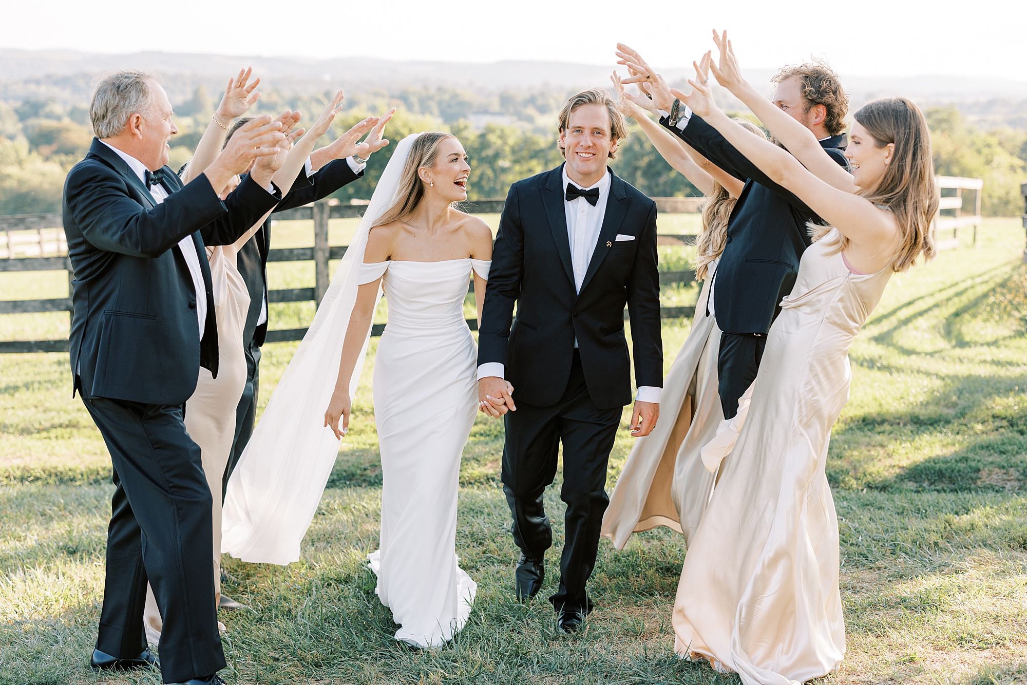 newlyweds walk under bridal party's hands and tunnel