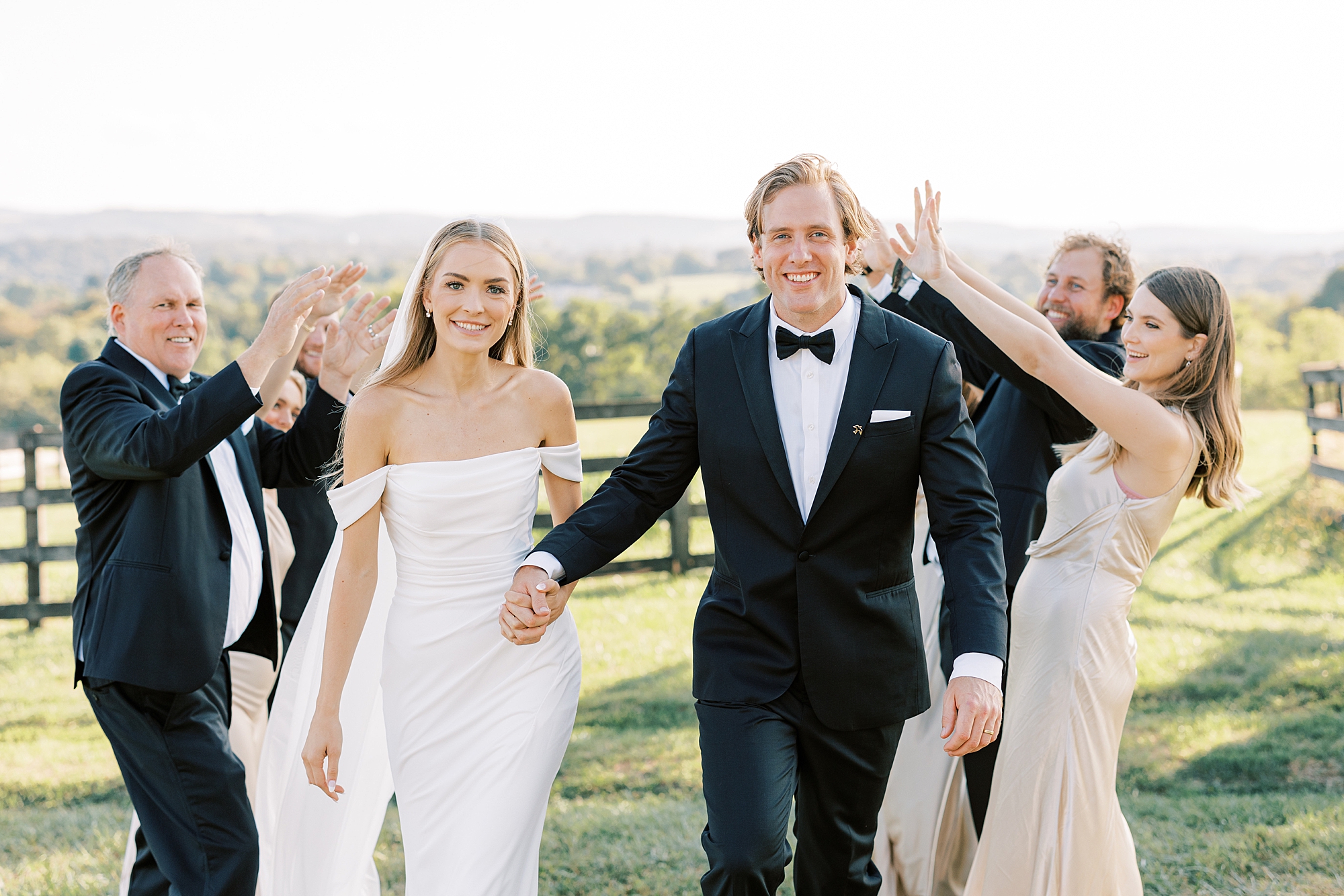 bride and groom hold hands with wedding party at Lauxmont Farms