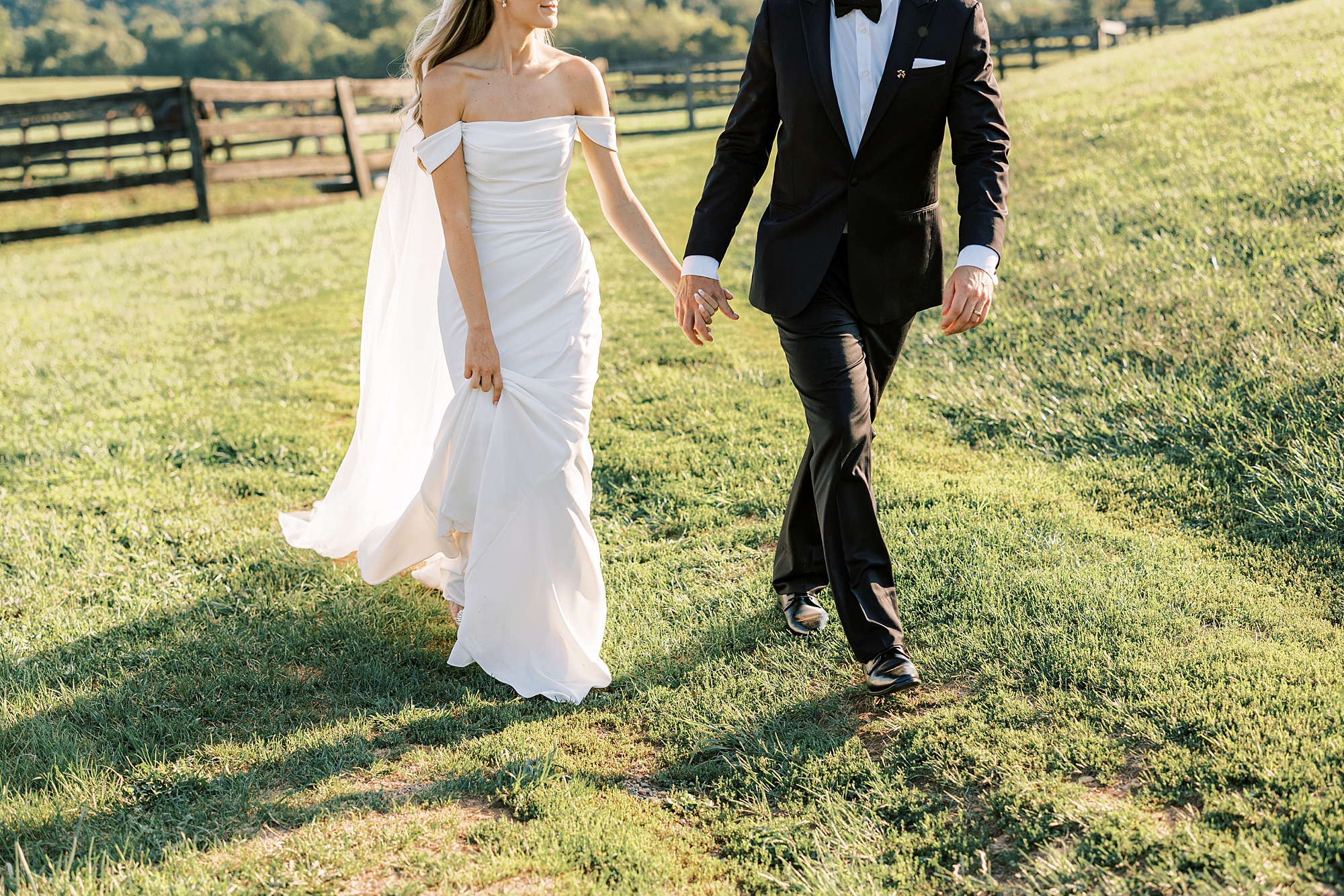 bride and groom hold hands during summer wedding day