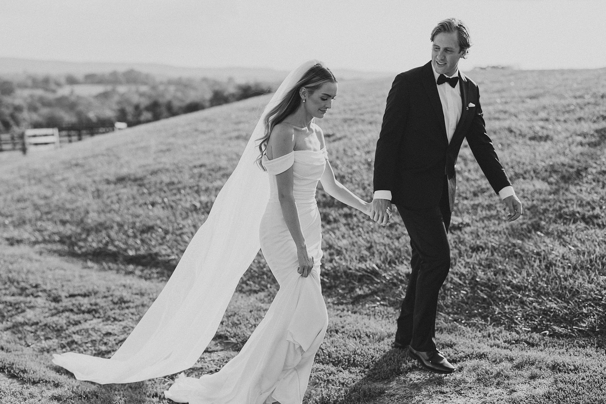 groom leads bride up hill during classic wedding day at Lauxmont Farms