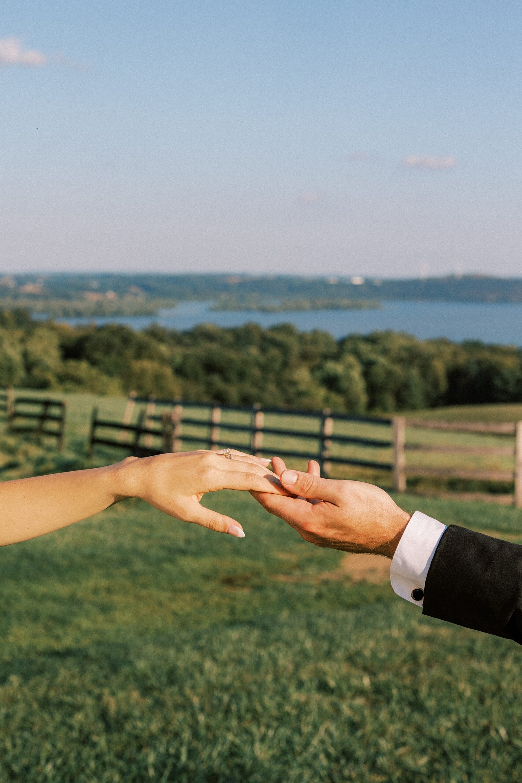 bride and groom hold hands with background of Lauxmont Farms behind them 