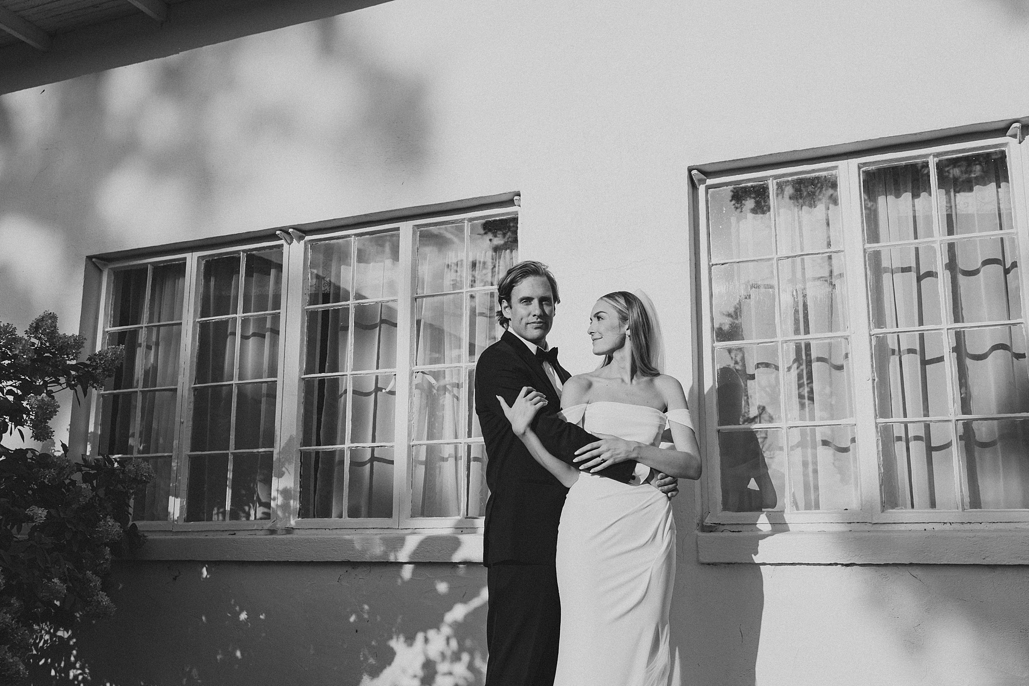 bride holds groom's arm looking back at her during portraits at Lauxmont Farms