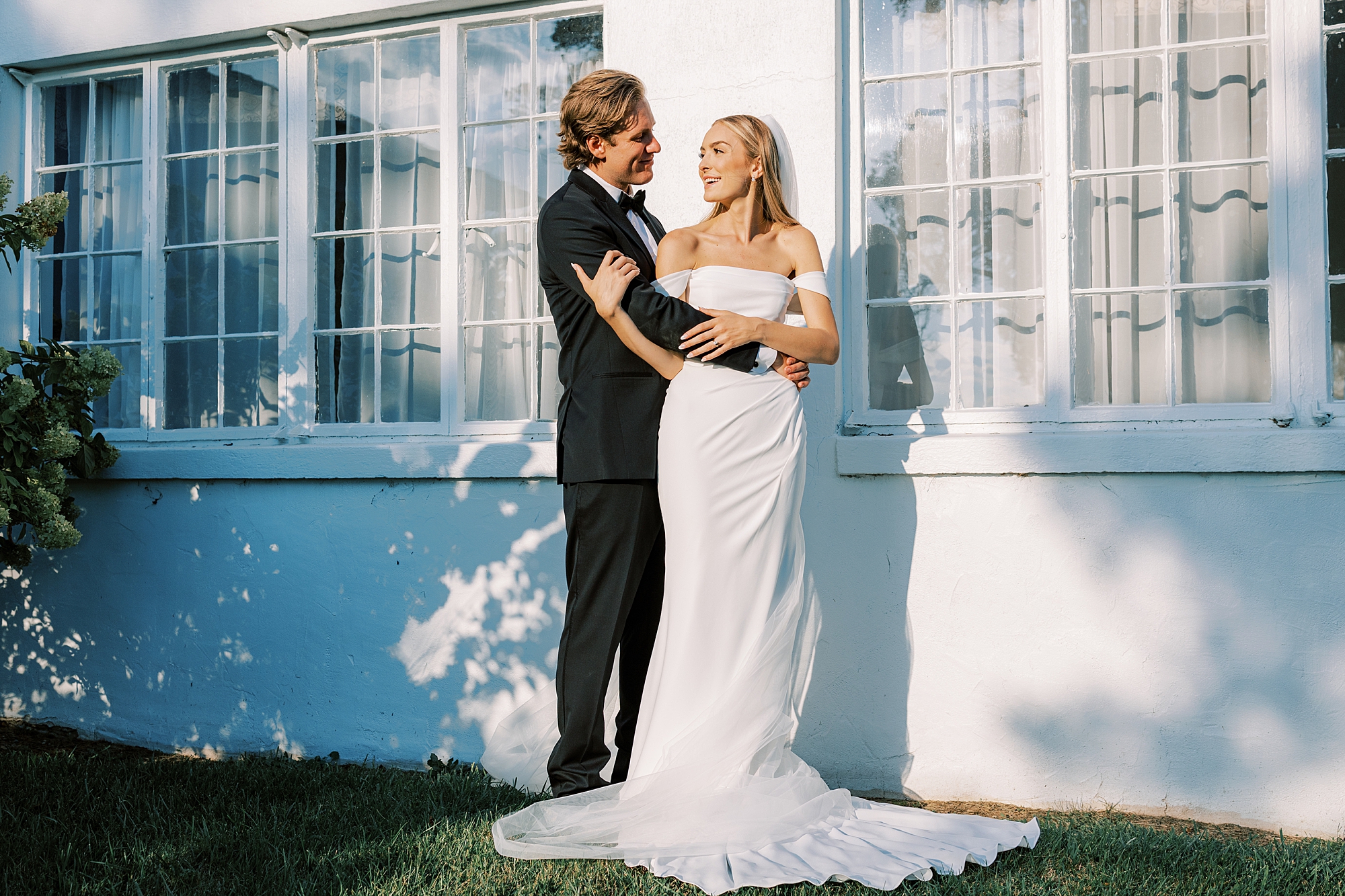 bride holds groom's arm looking back at him inside Lauxmont Farms