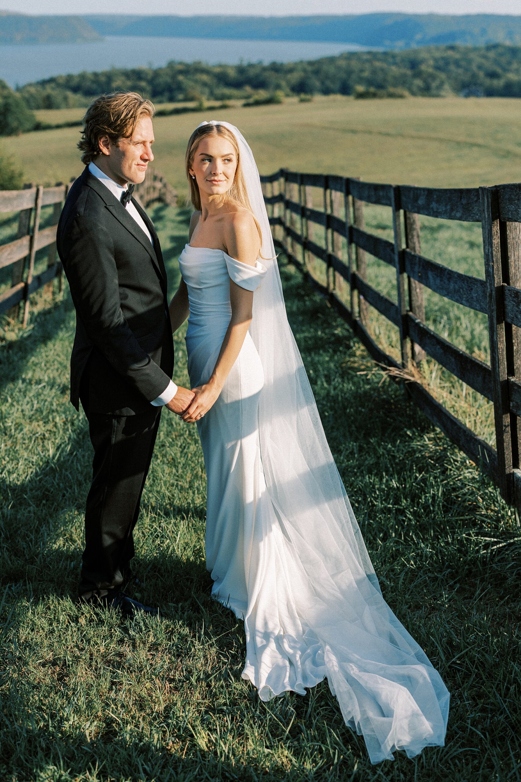 bride and groom hug between black fences at Lauxmont Farms