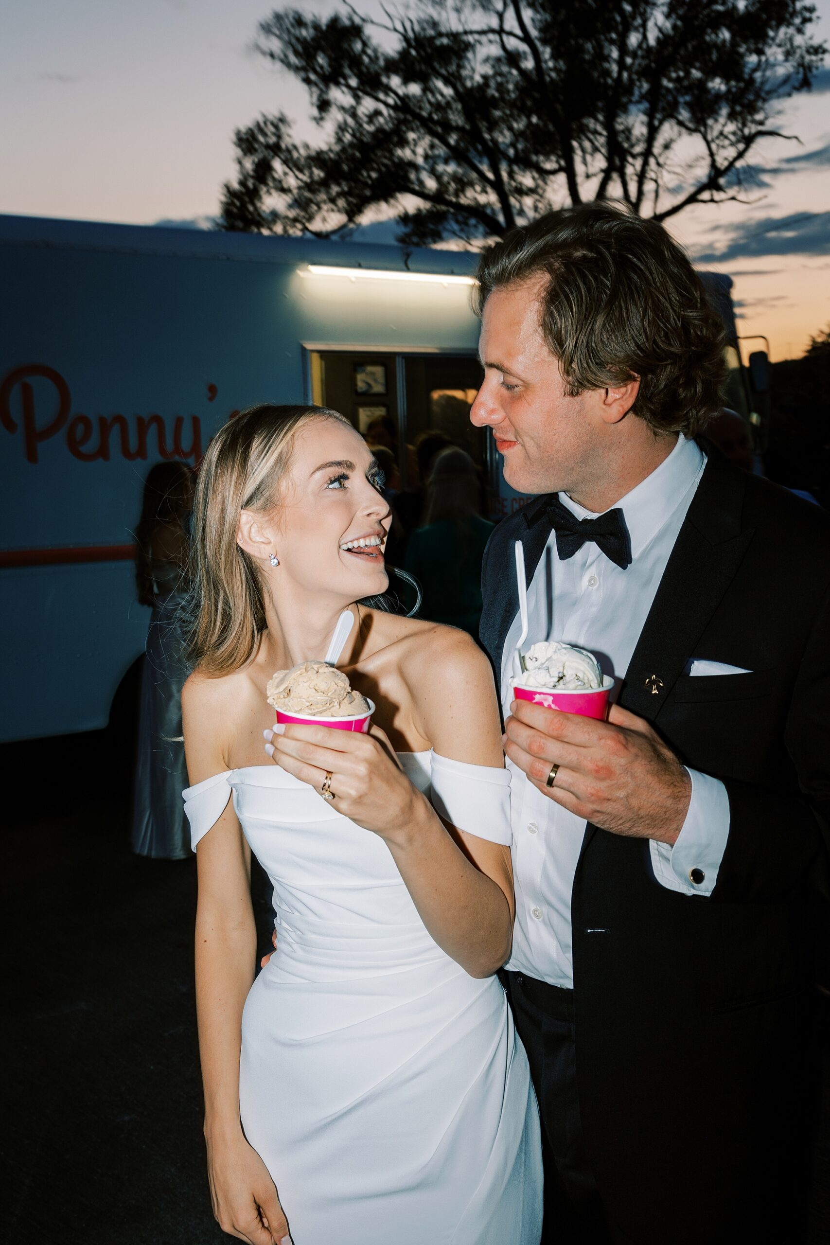 bride and groom smiling cup of Penny's ice cream from food truck