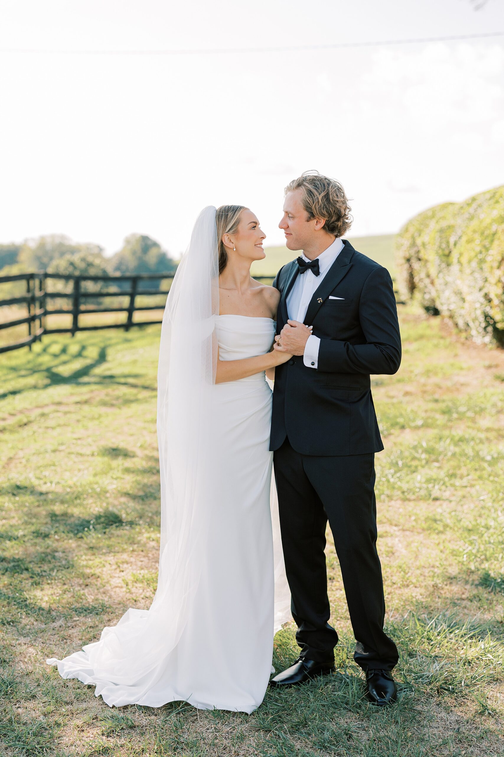 bride and groom hug on lawn on hill at Lauxmont Farms