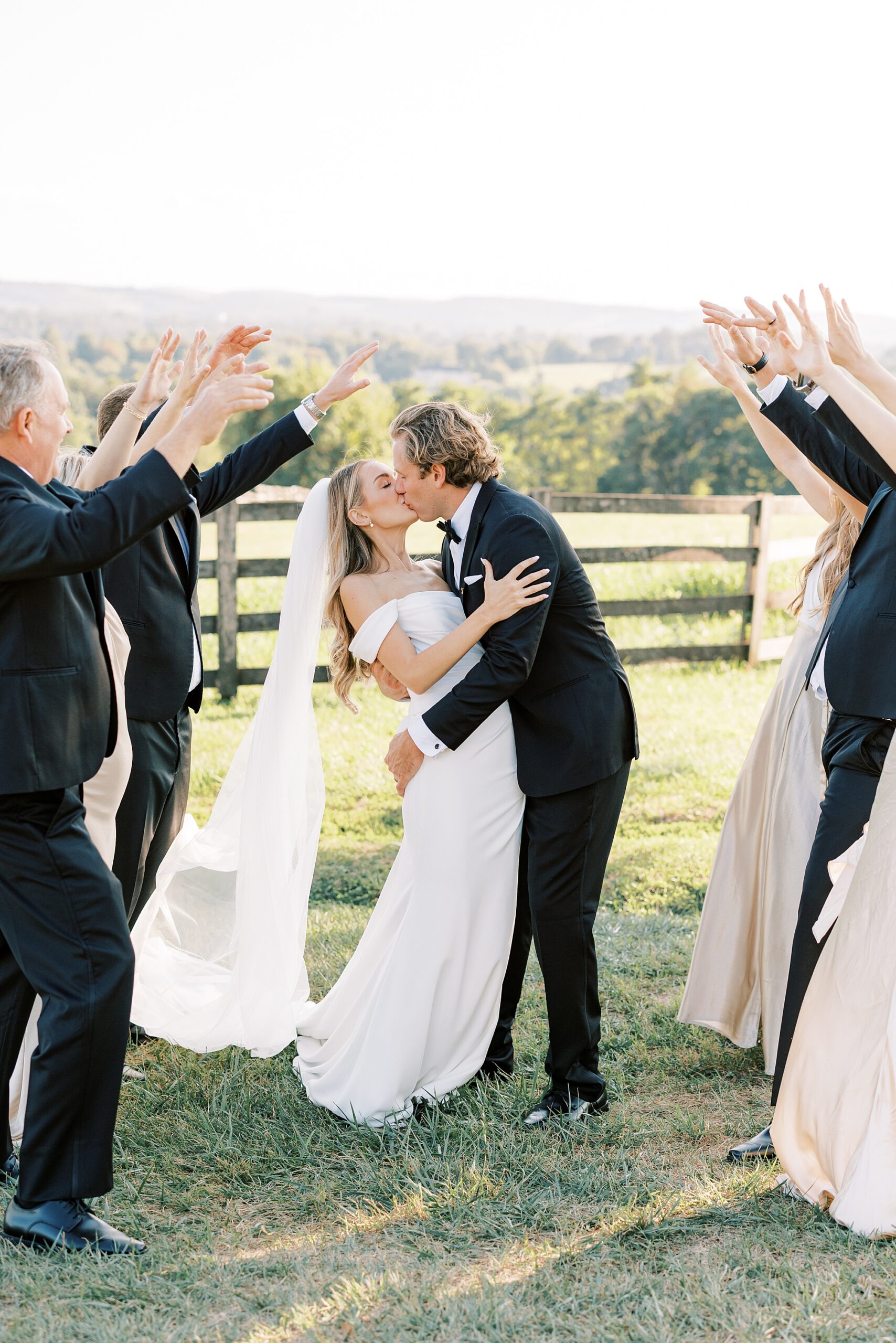 newlyweds cheer while bridal party makes tunnel with hands 