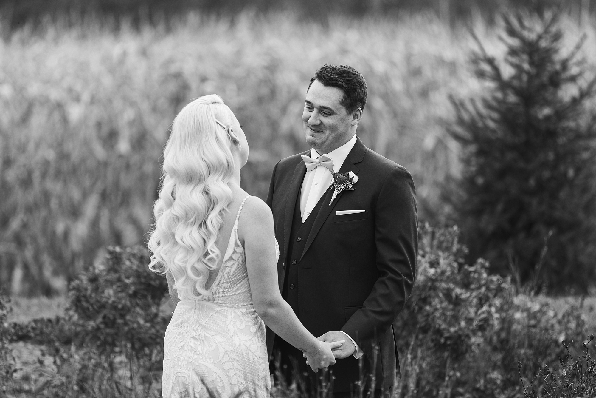 groom smiles at bride in field at Osbornia Farm