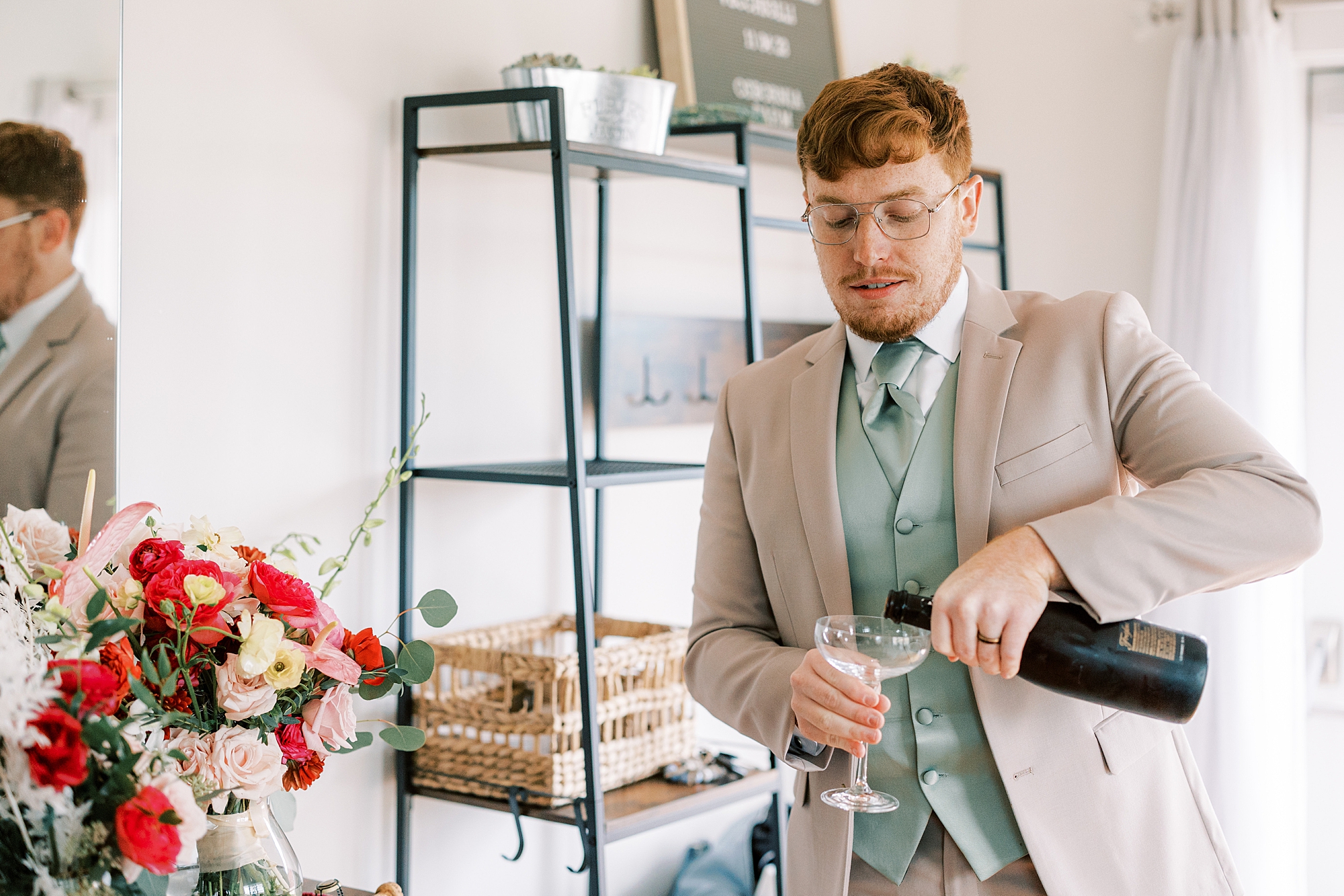 groomsman pours champagne during prep for Osbornia Farm wedding