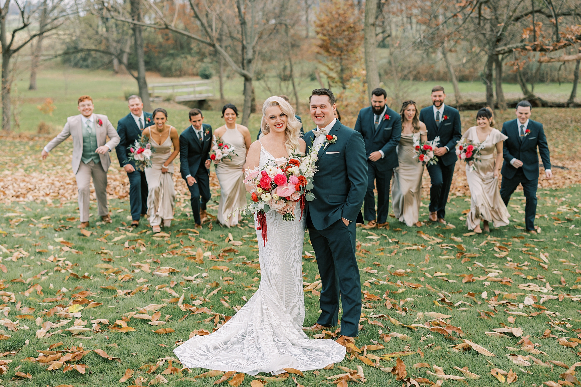 newlyweds hug in front of wedding party on lawn at Osbornia Farm