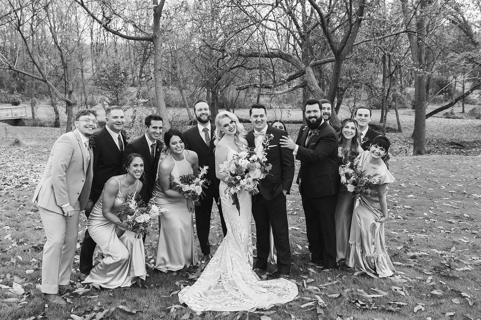 newlyweds hug with wedding party around them at Osbornia Farm