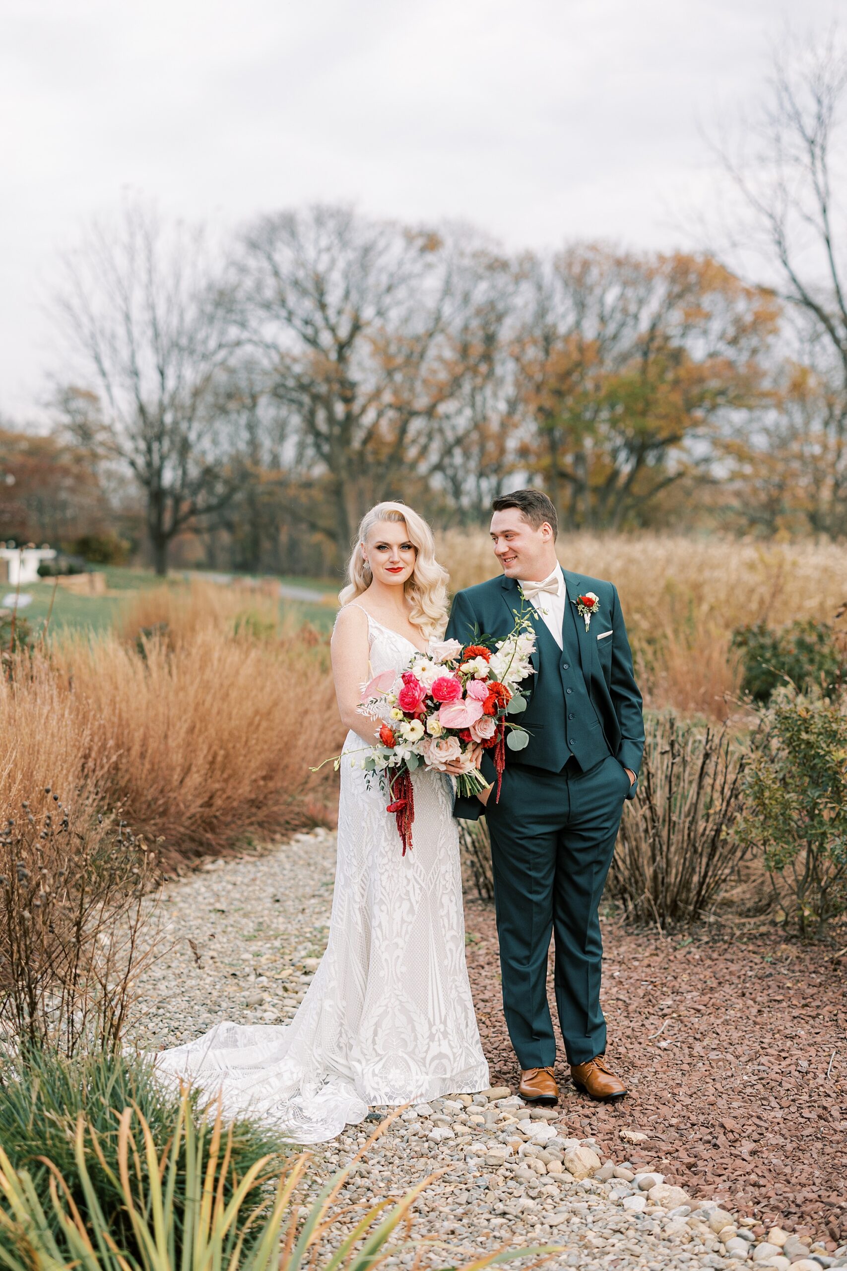 groom looks over at bride hugging her during fall wedding