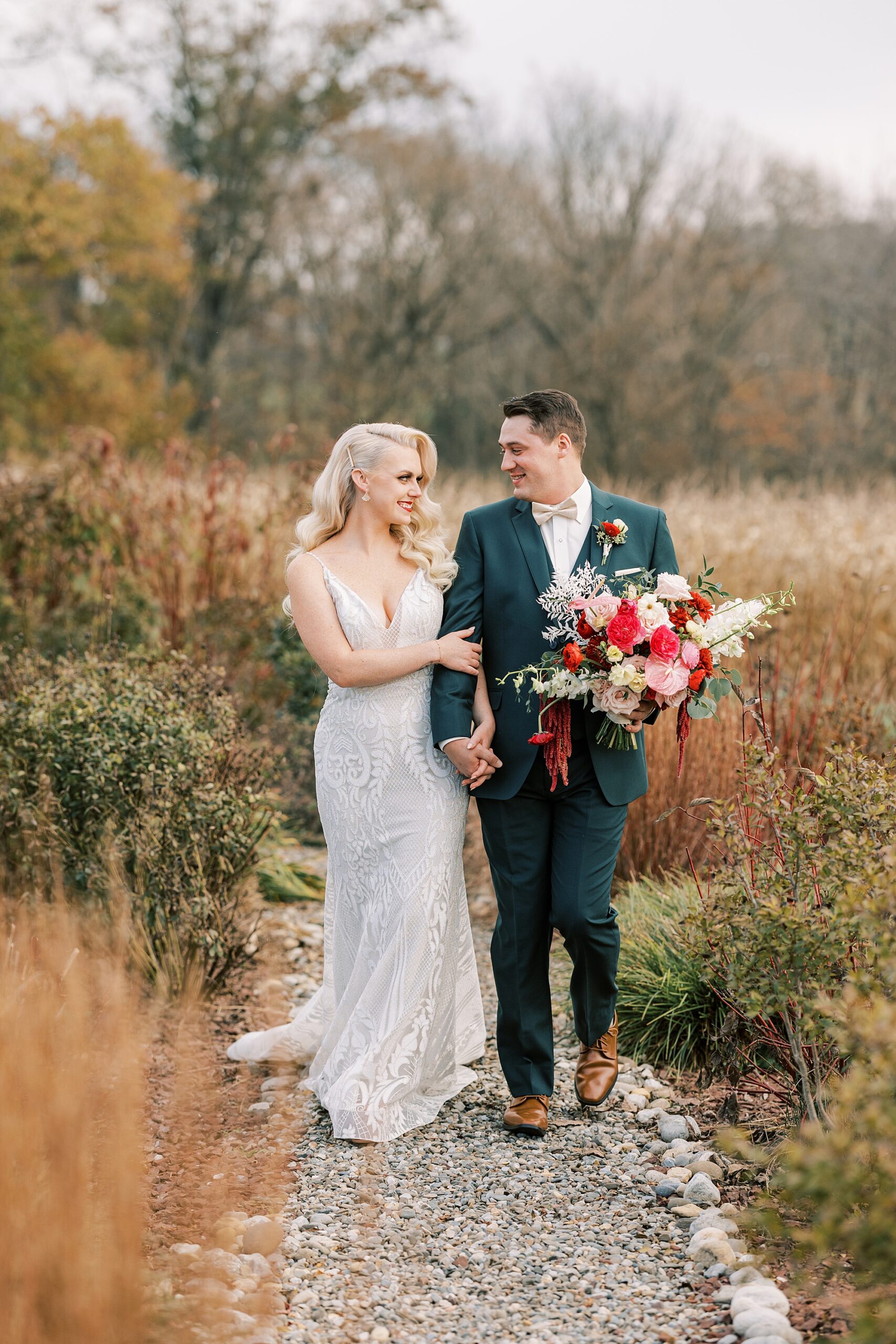 bride and groom walk down path during garden at Osbornia Farm