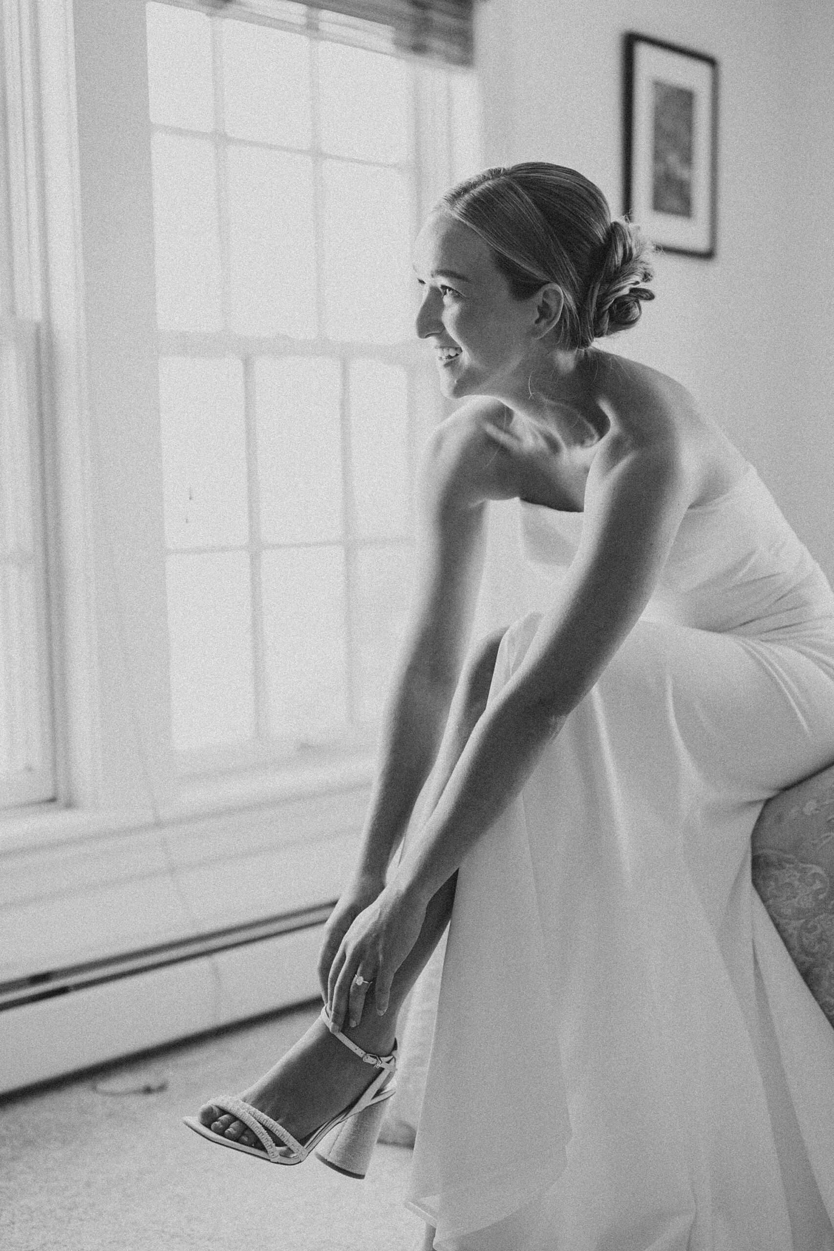 bride leans down to adjust shoes during prep for NJ wedding day