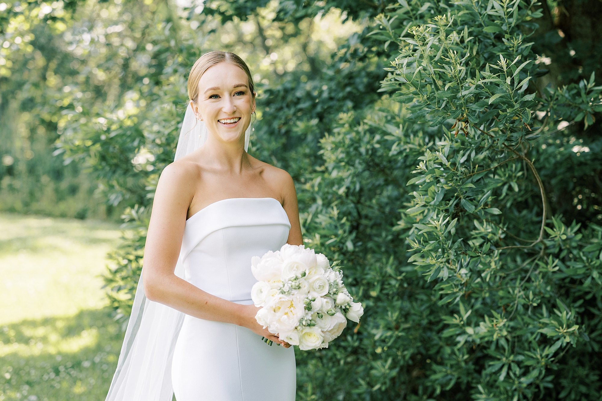 bride in strapless wedding dress holds ivory bouquet for summer wedding at Willow Creek Winery