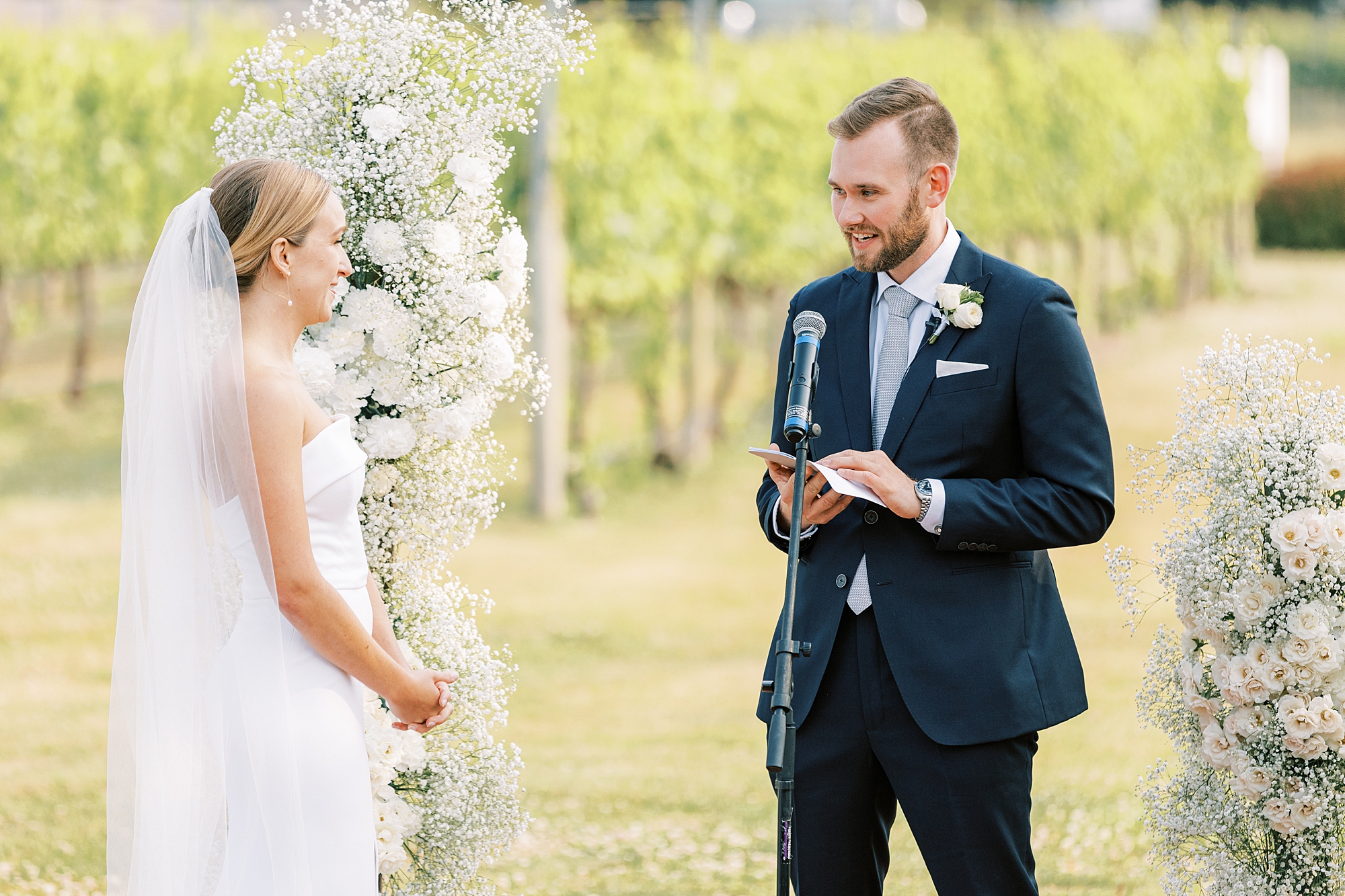 groom reads vows to bride during wedding ceremony at Willow Creek Winery