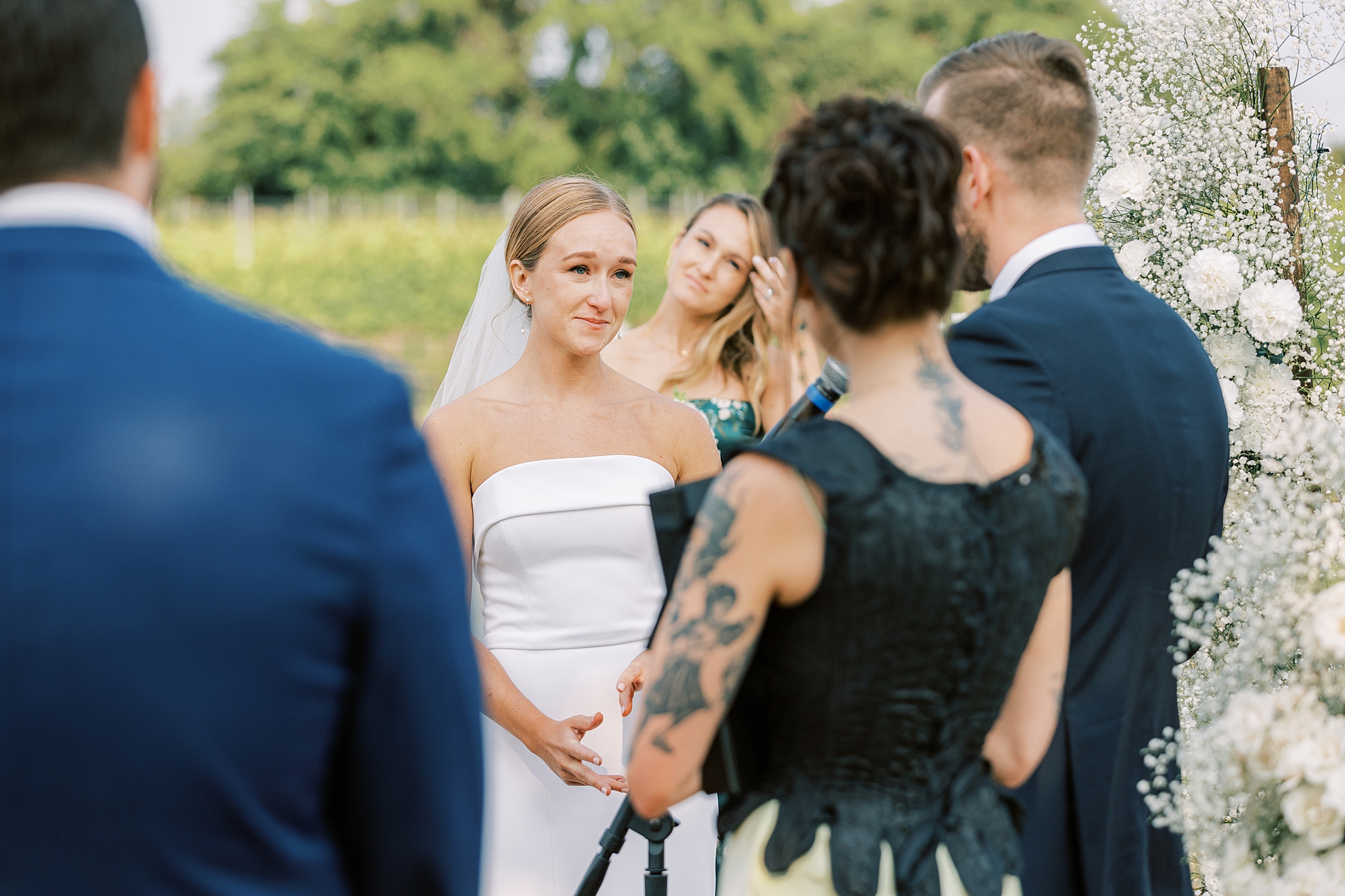 bride smiles looking at groom during wedding ceremony at Willow Creek Winery
