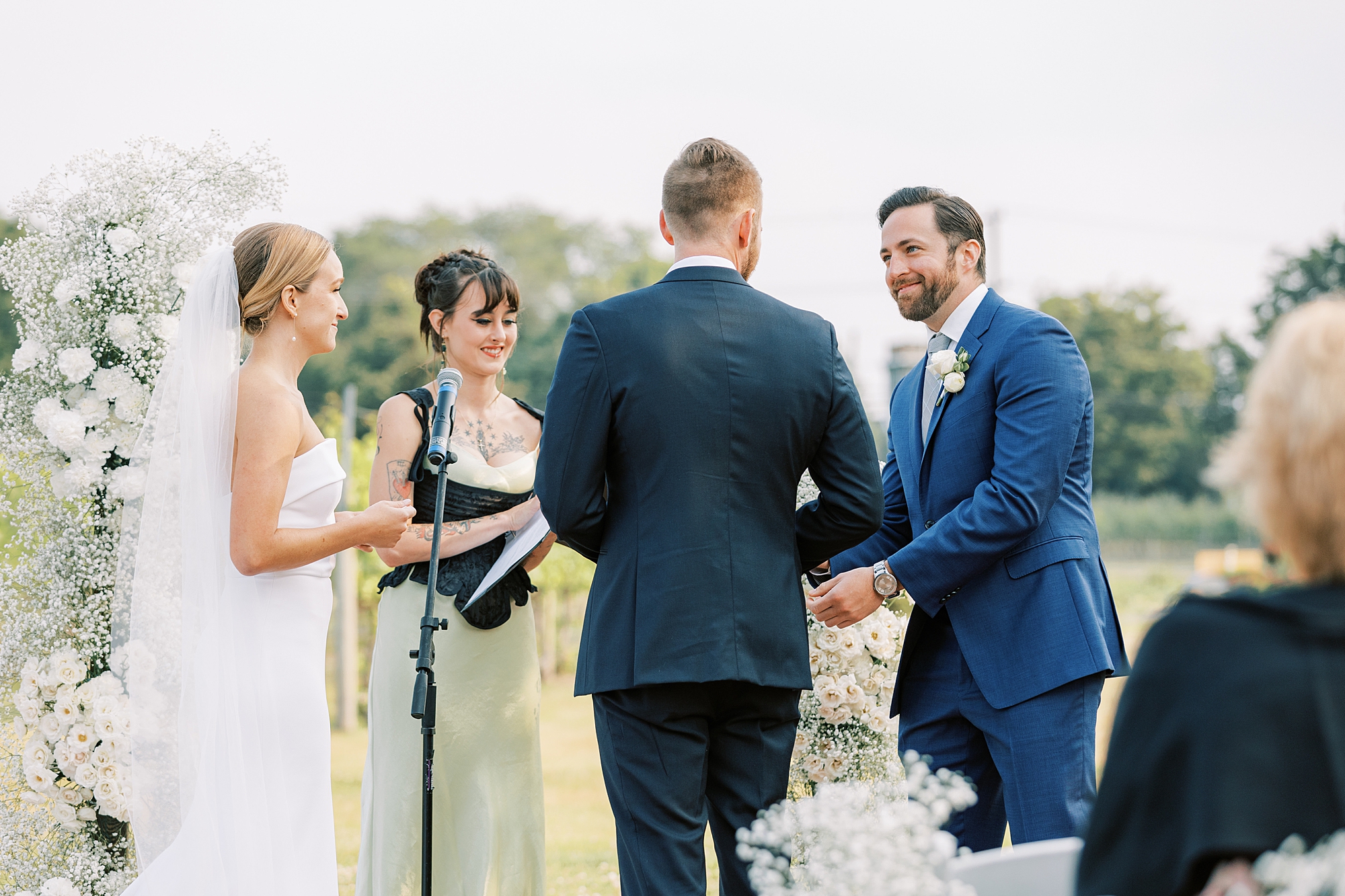 groomsman gives groom rings during wedding ceremony at Willow Creek Winery