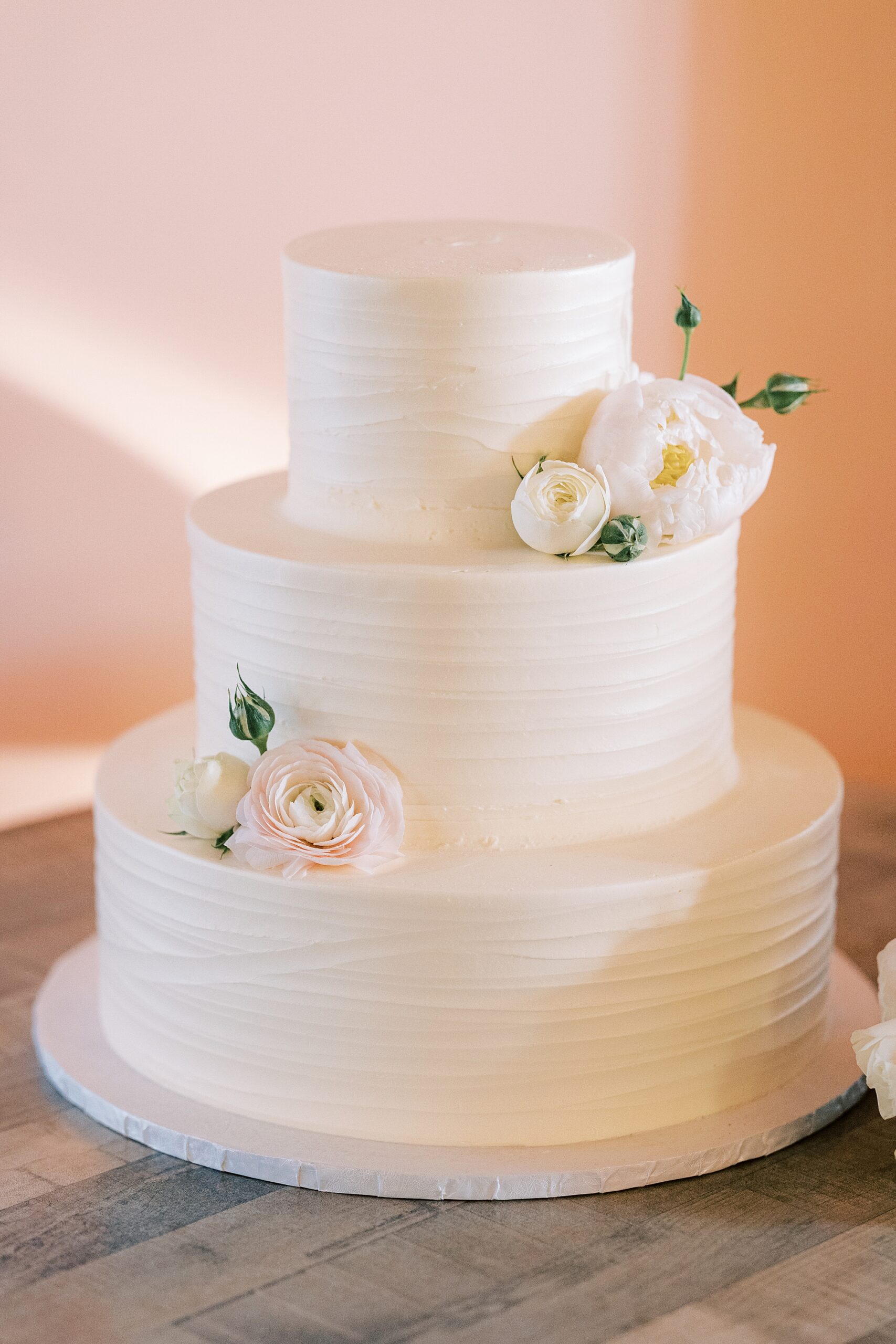 tiered wedding cake with rose accents at Willow Creek Winery