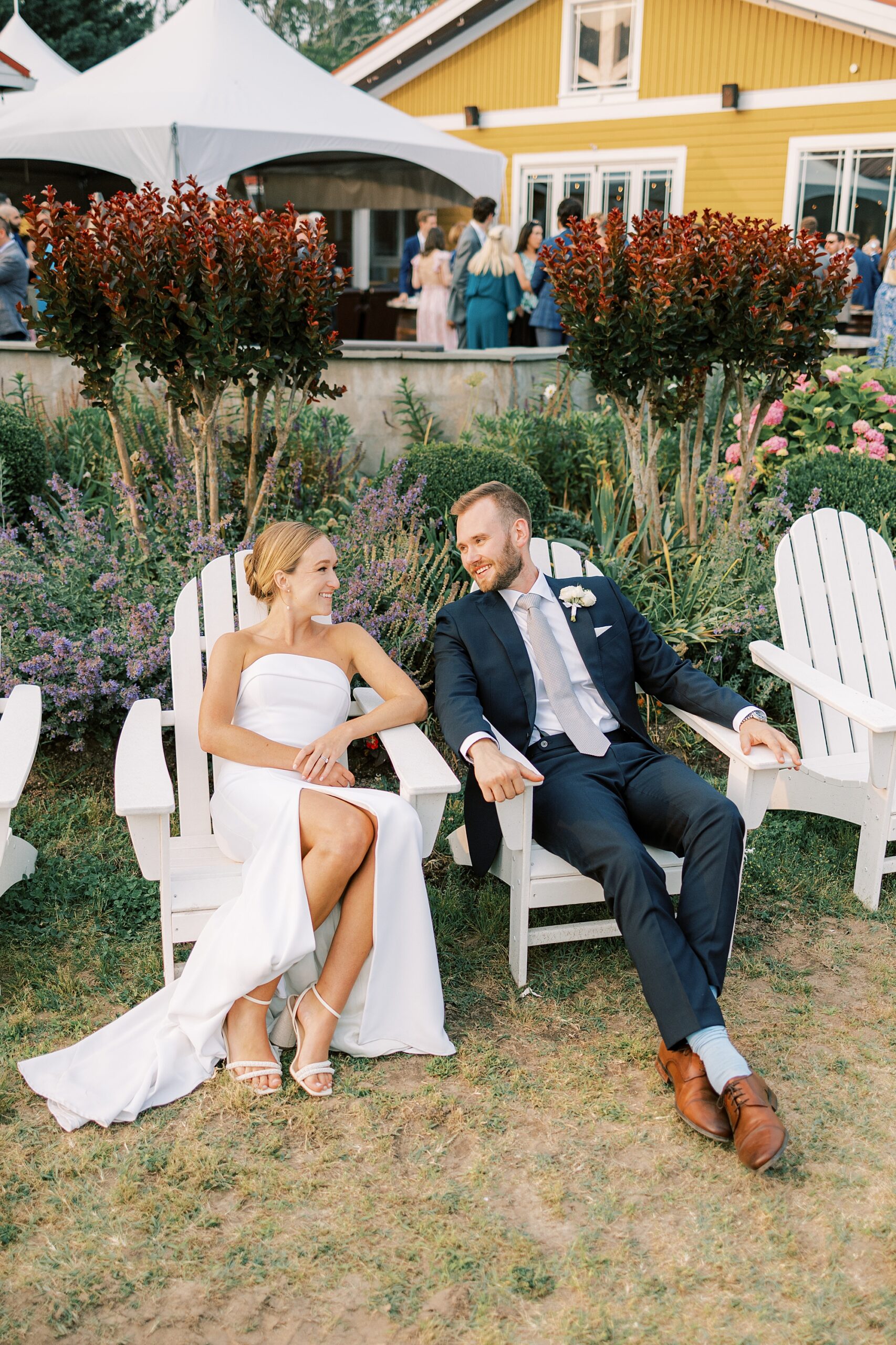 bride and groom sit in Adirondack chairs at Willow Creek Winery