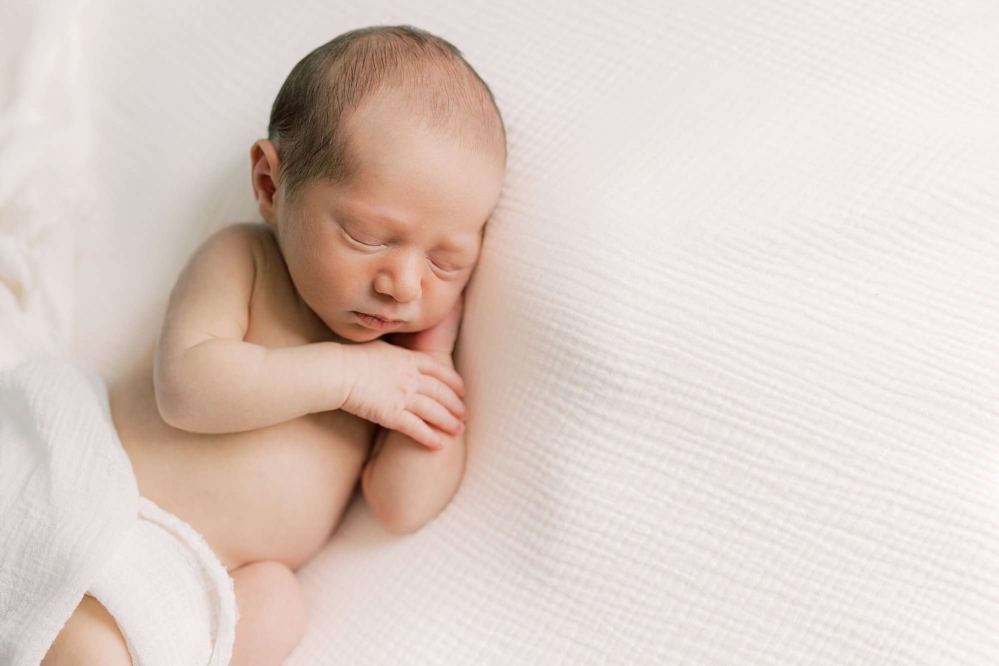 baby boy lays on white blanket during Chadds Ford PA newborn session