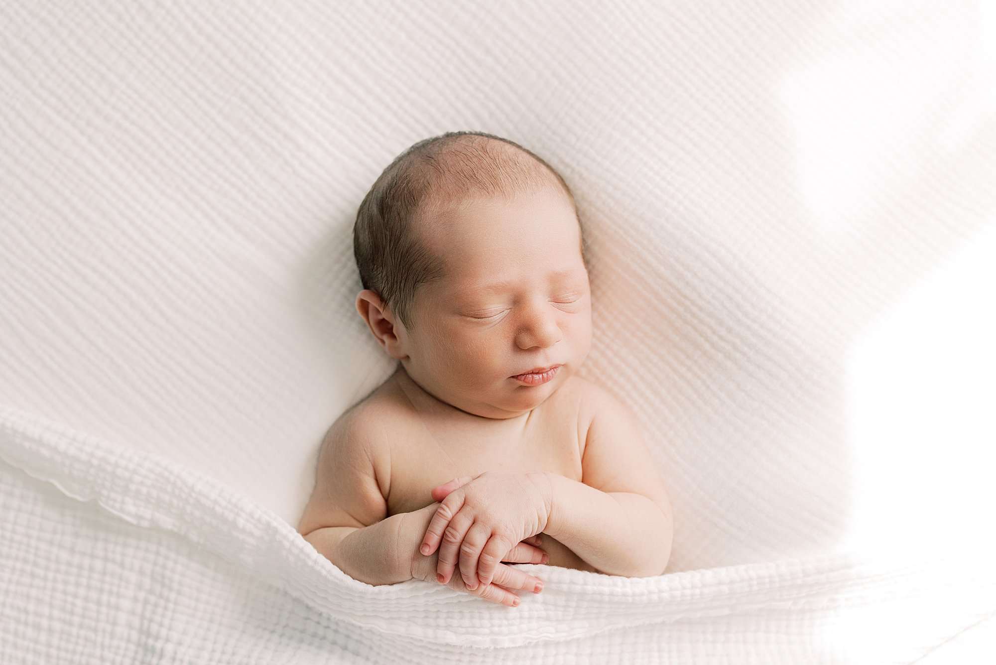 baby lays tucked into blanket on bed during Chadds Ford PA newborn session