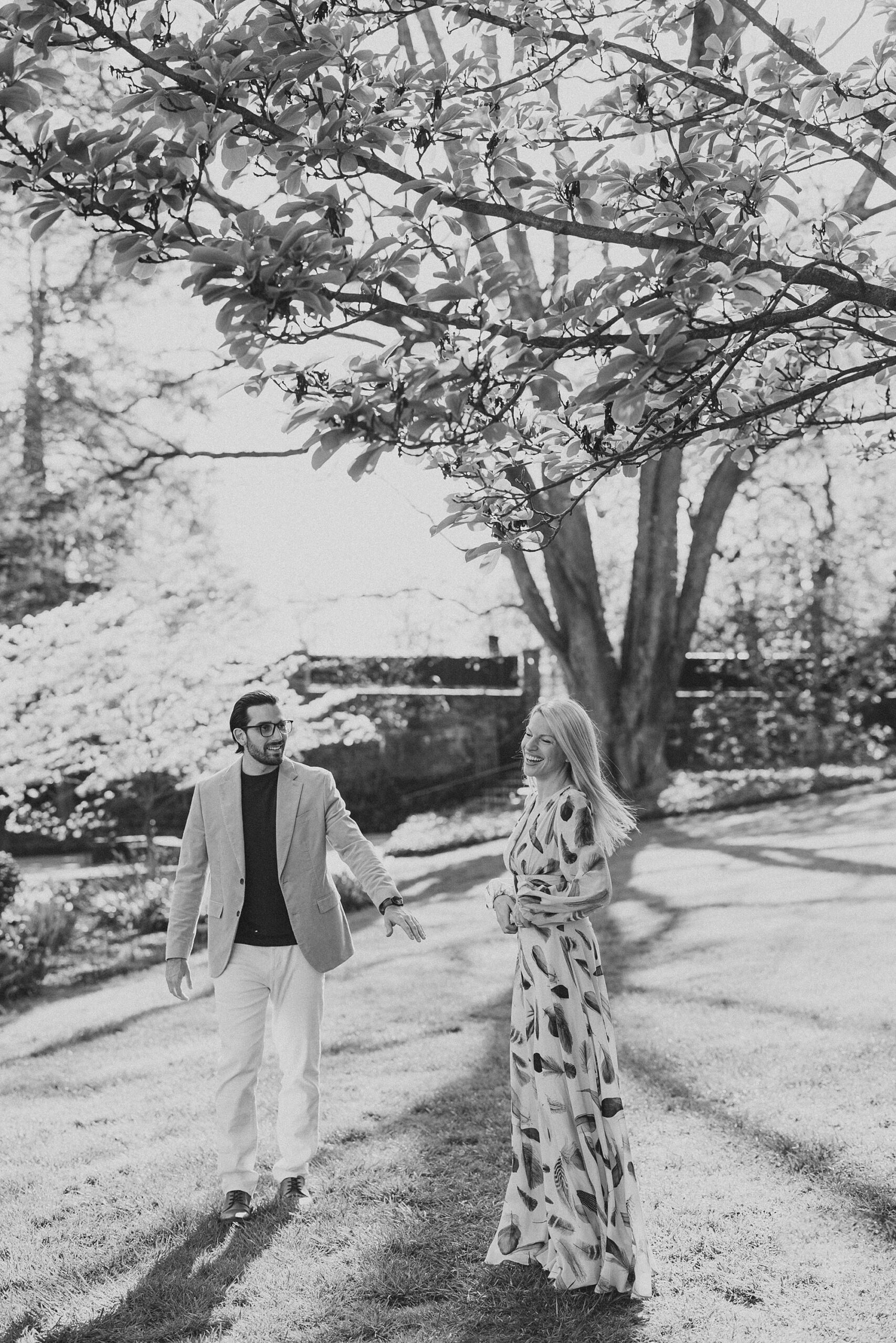 engaged couple holds hands walking through Longwood Gardens
