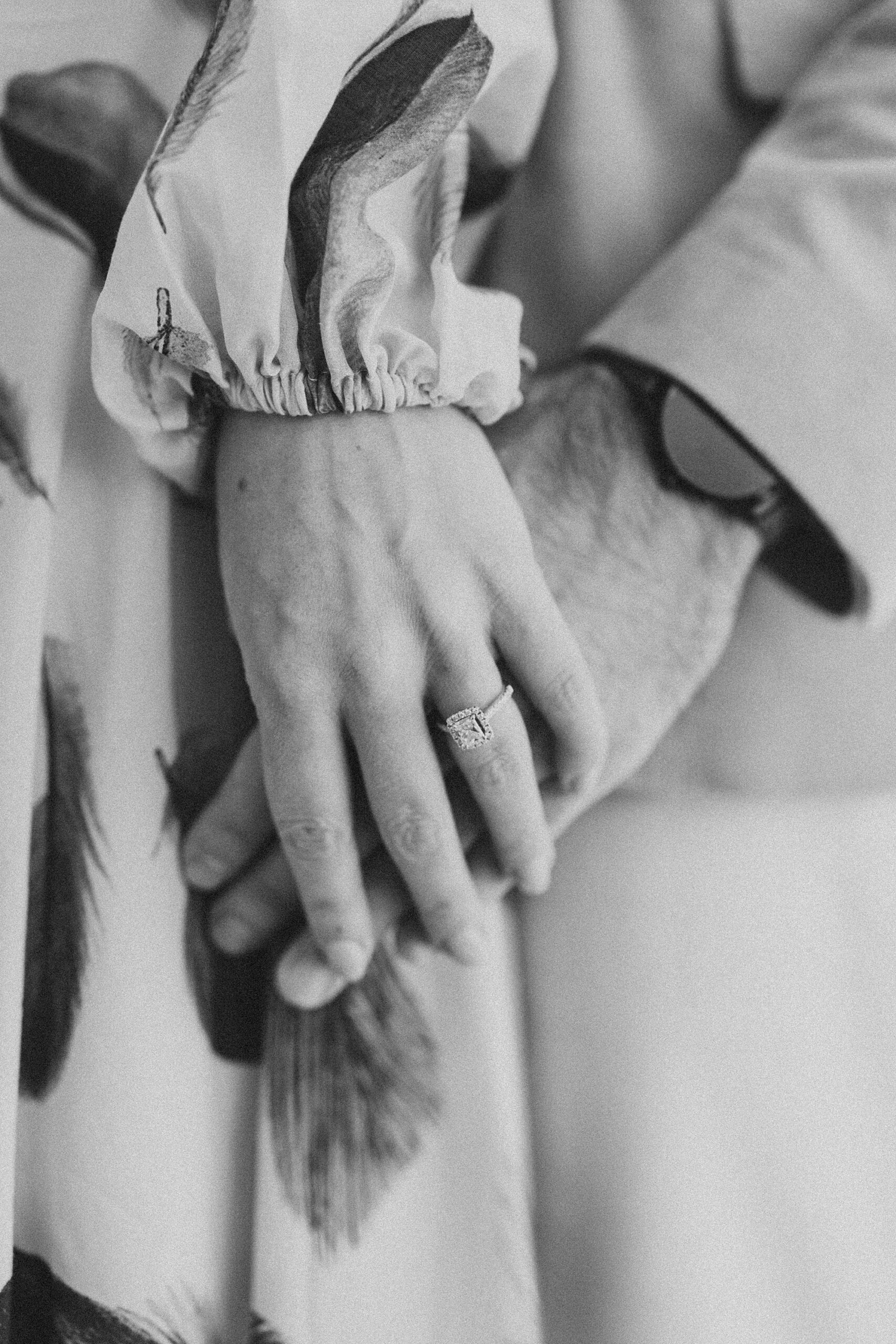 woman holds man's hand showing off engagement ring during Longwood Gardens photos 