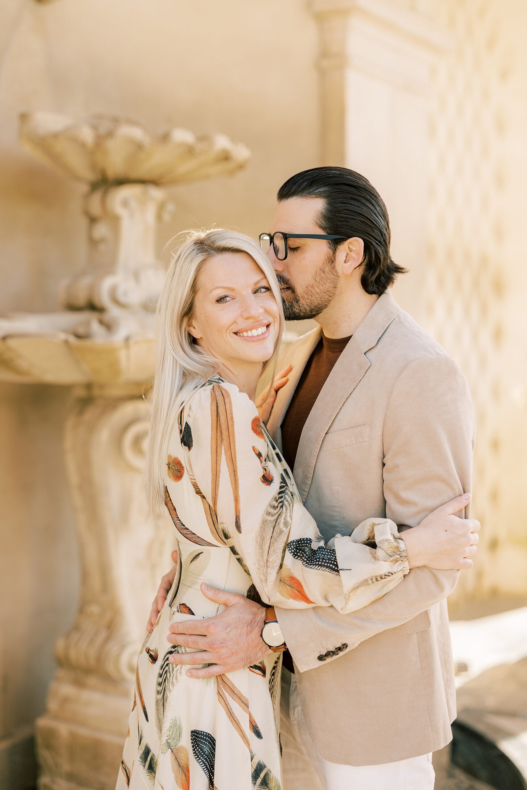 man leans to kiss woman's forehead during engagement session at Longwood Gardens