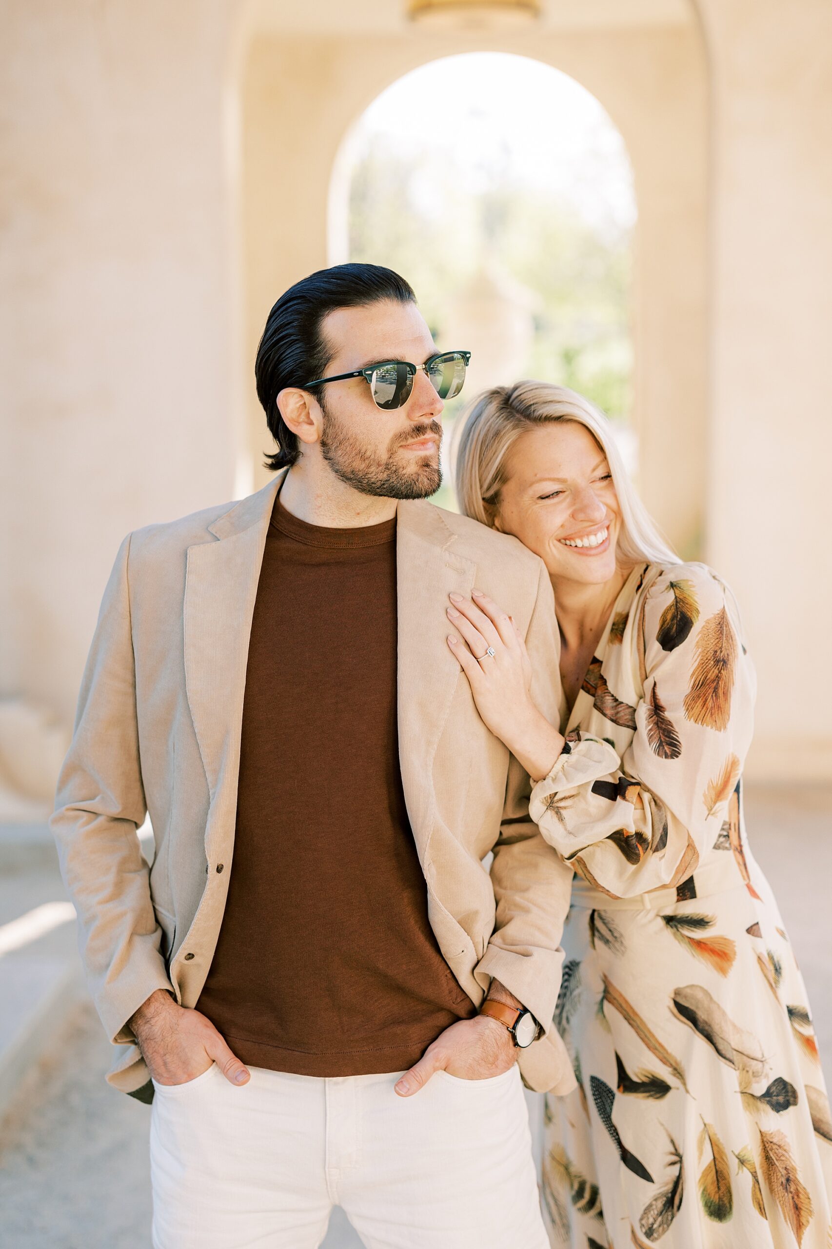 woman laughs leaning into fiancee during spring engagement session at Longwood Gardens