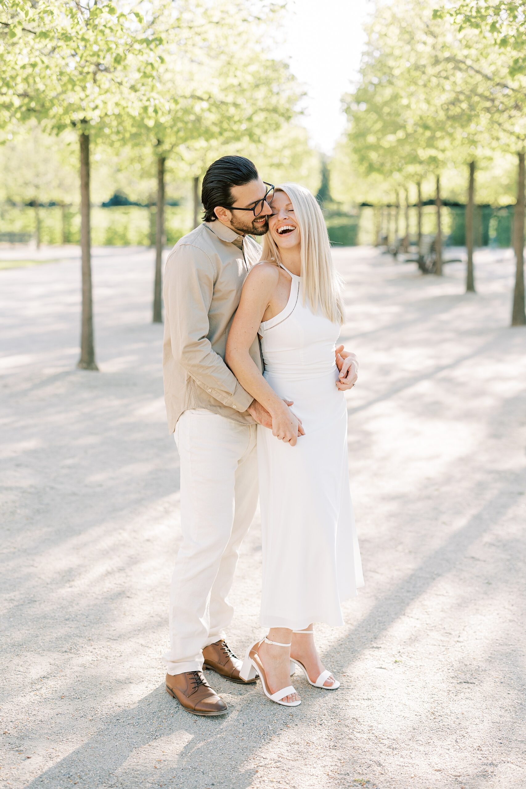 blonde woman leans into fiancee during spring engagement session at Longwood Gardens