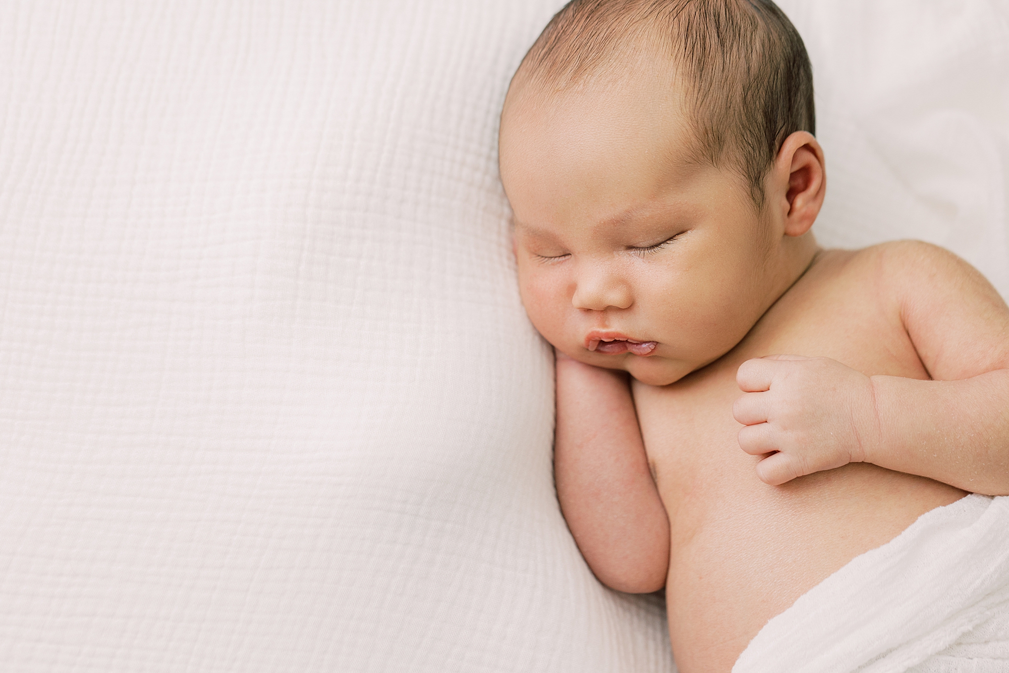 baby boy lays on ivory blanket during Cherry Hill NJ newborn session