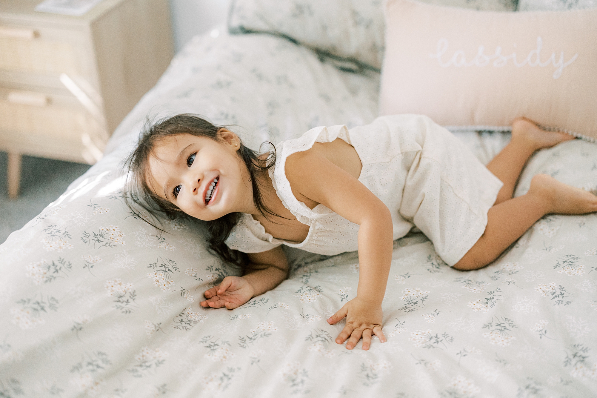 older sister plays on bed during lifestyle family photos 