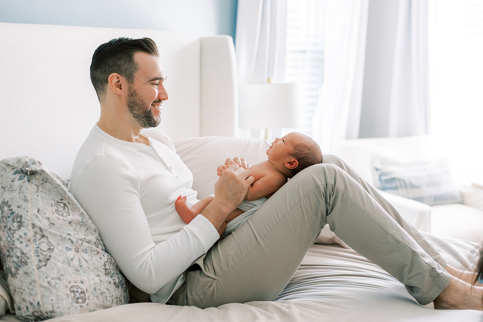 dad holds son on bent knees during newborn session in Cherry Hill NJ