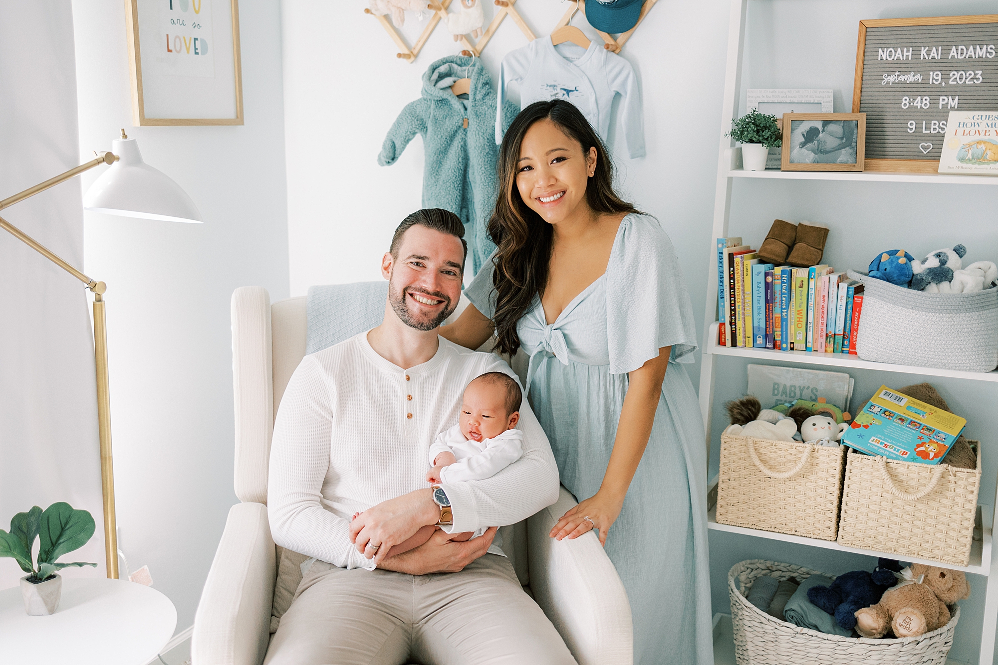 couple poses in nursery with son in rocking chair during NJ newborn session