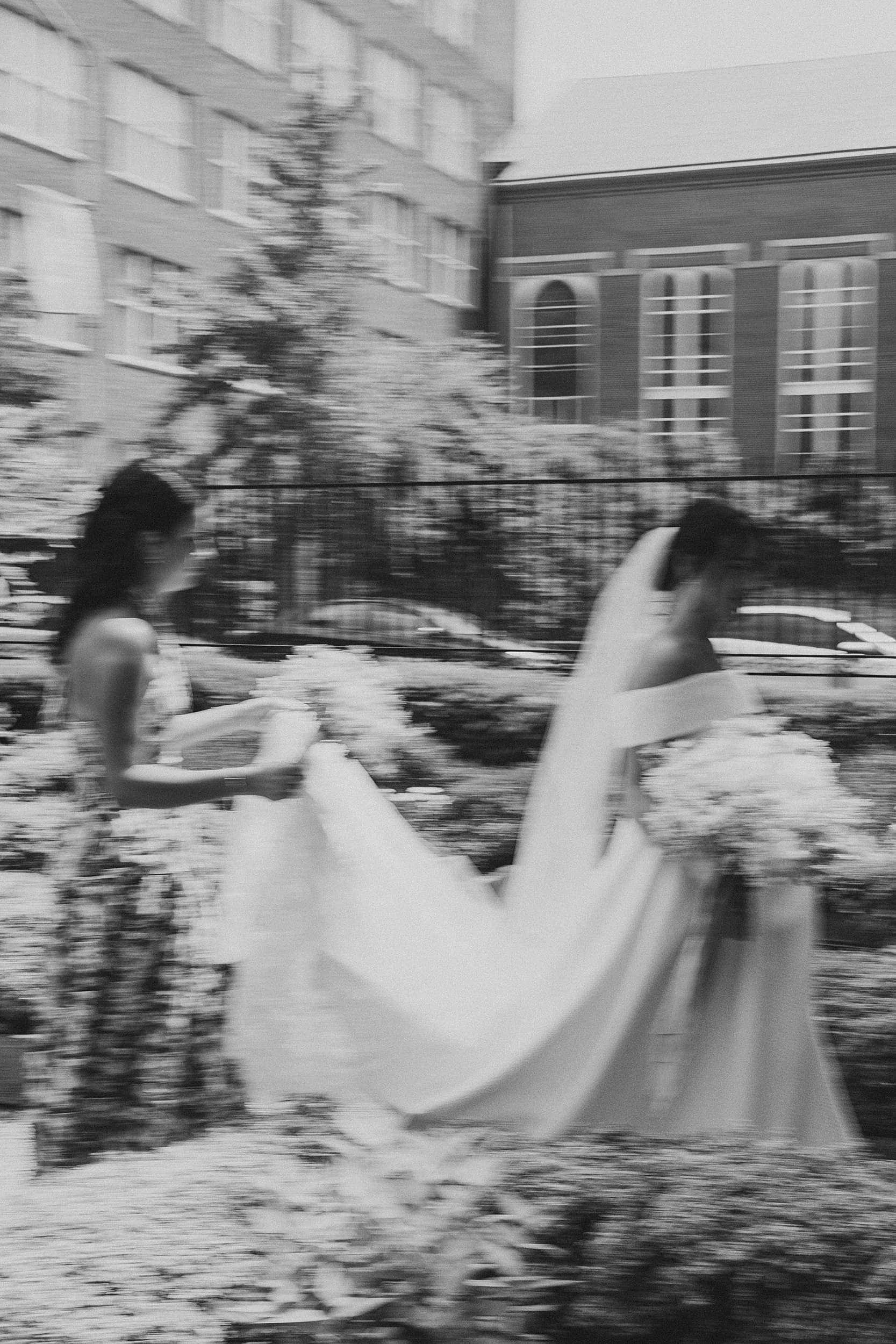 black and white artistic image of bride and her sister walking through the Philadelphia streets