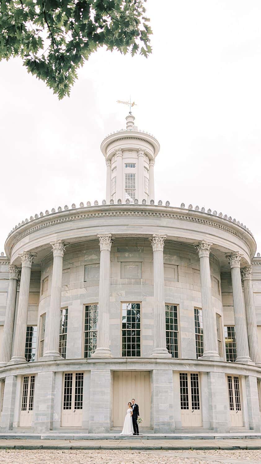 Bride and Groom pose in front of the Merchant Exchange building at their Philadelphia wedding 