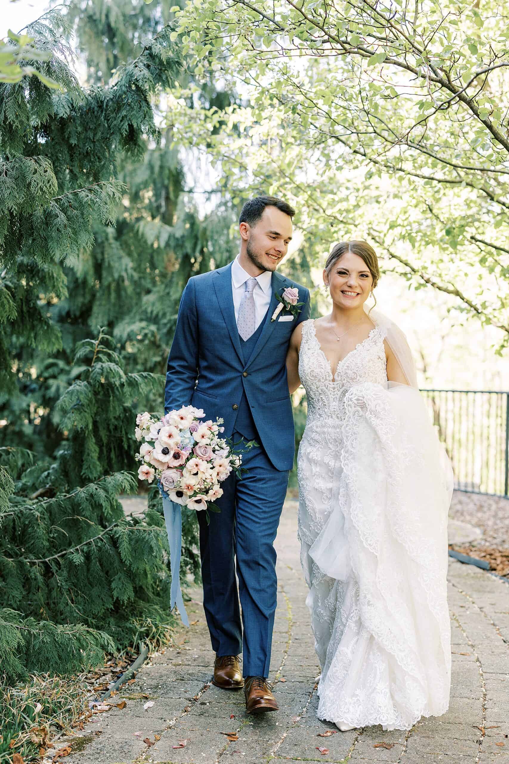 bride and groom walk together on stone walkway at Lake House Inn